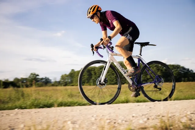 Cyclist riding on an open road, focused on effort and movement