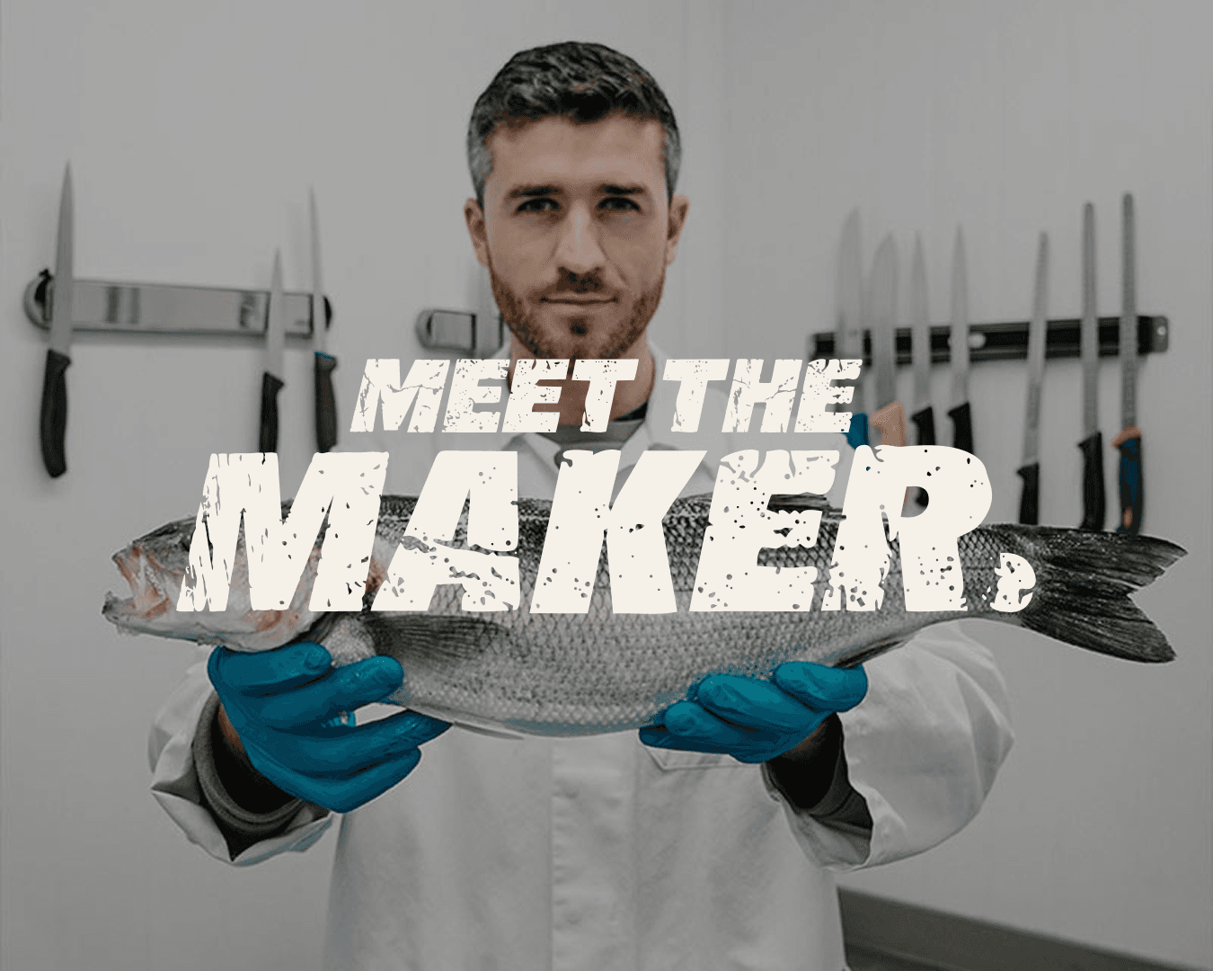 Fishmonger in a white coat and blue gloves holding a whole fresh fish, with knives hanging in the background. Overlaid text reads “MEET THE MAKER.”