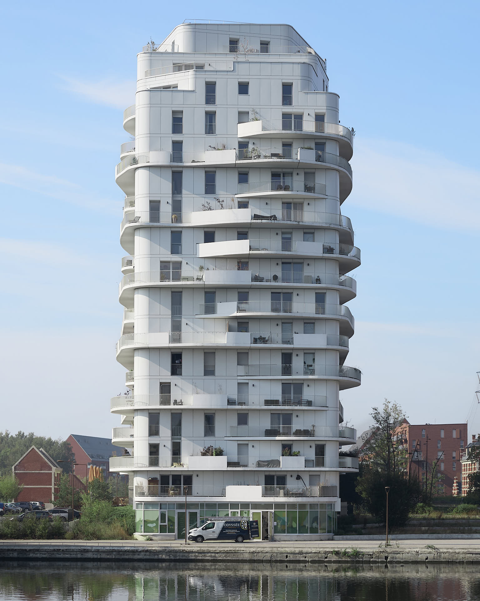 Vue du haut et de la façade de l'immeuble Brooklyn Tower à Marquette-lez-Lille, isolé par un ciel bleu peu nuageux.