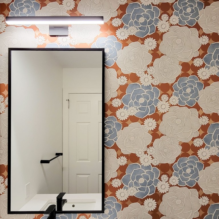 Image of Luxury bathroom interior design featuring floral wallpaper and modern sink with KHD Homes design-build construction expertise.