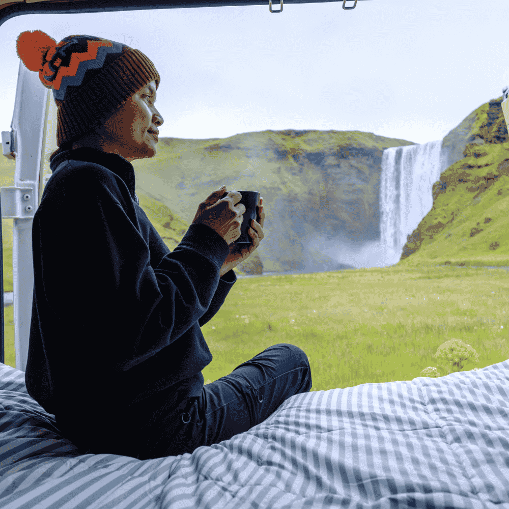 A woman relaxing in camper van near Skógafoss waterfall South Iceland scenic stop along the Volcanic Way route