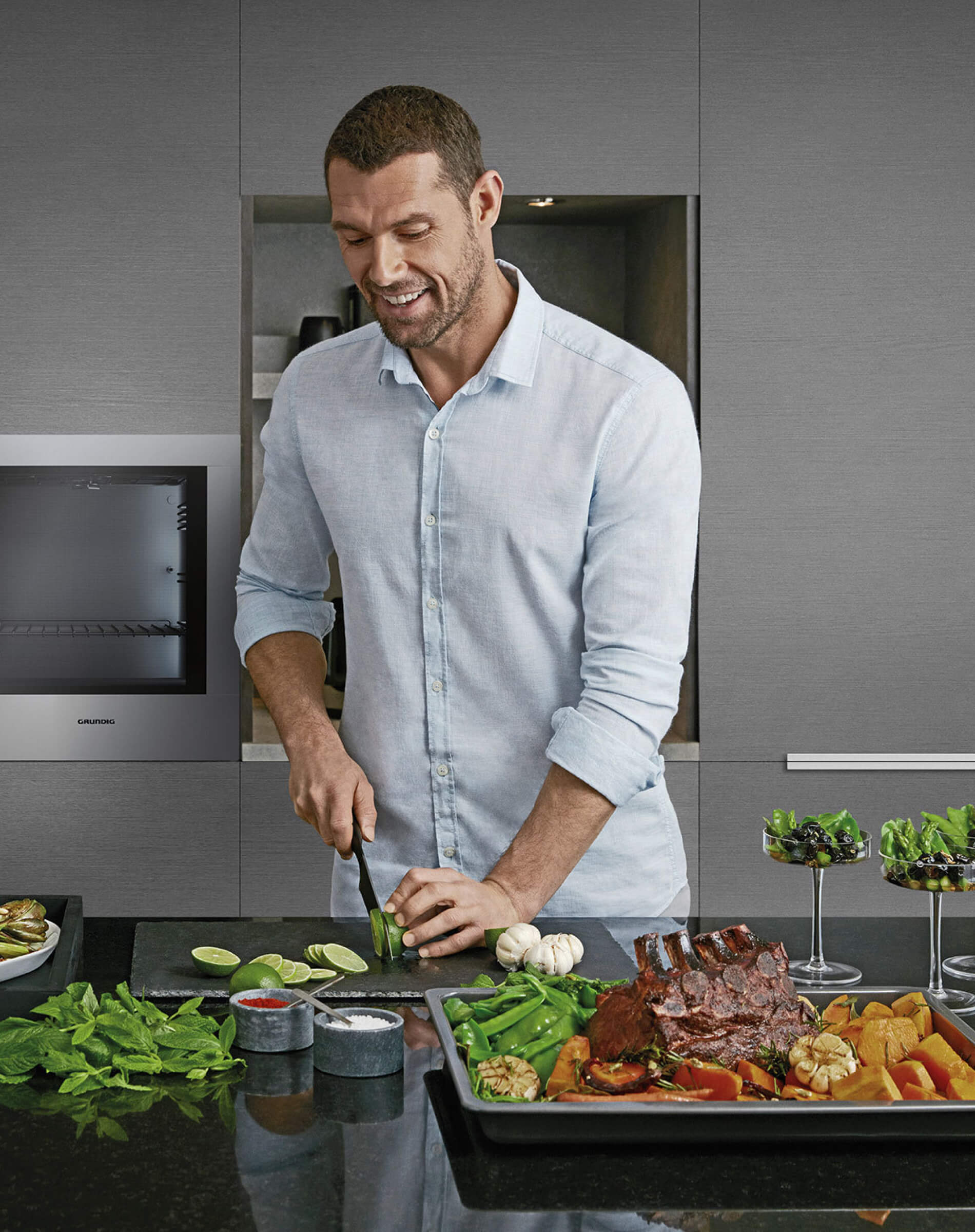 Man preparing a healthy meal in a modern kitchen equipped with Grundig appliances, highlighting lifestyle and wellness.