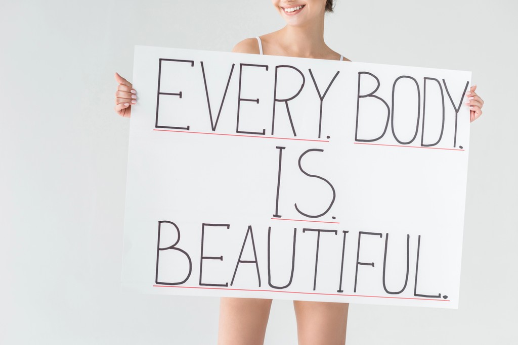 Woman holding sign that reads every body is beautiful