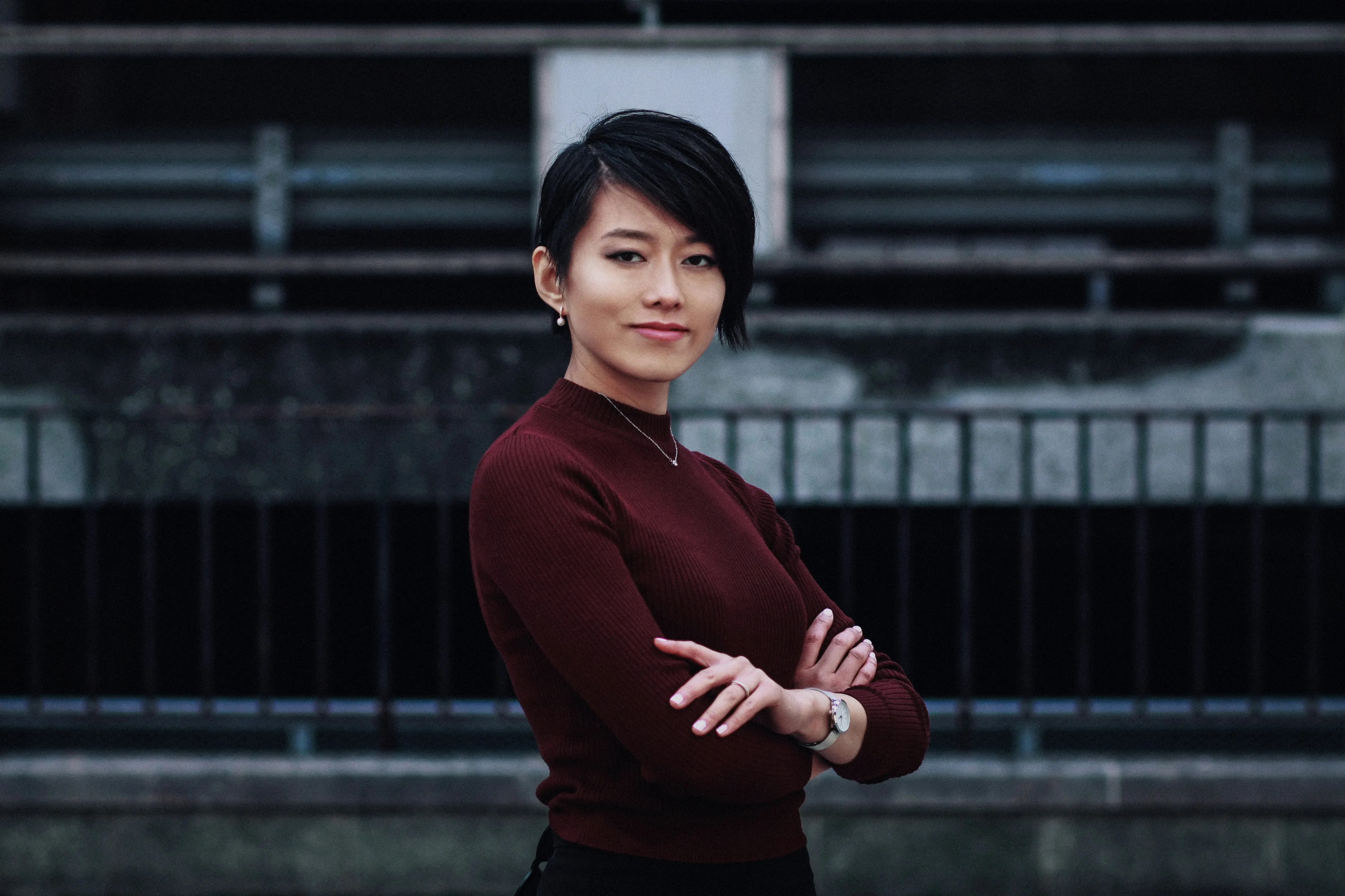 A woman standing with her arms crossed in front of a building