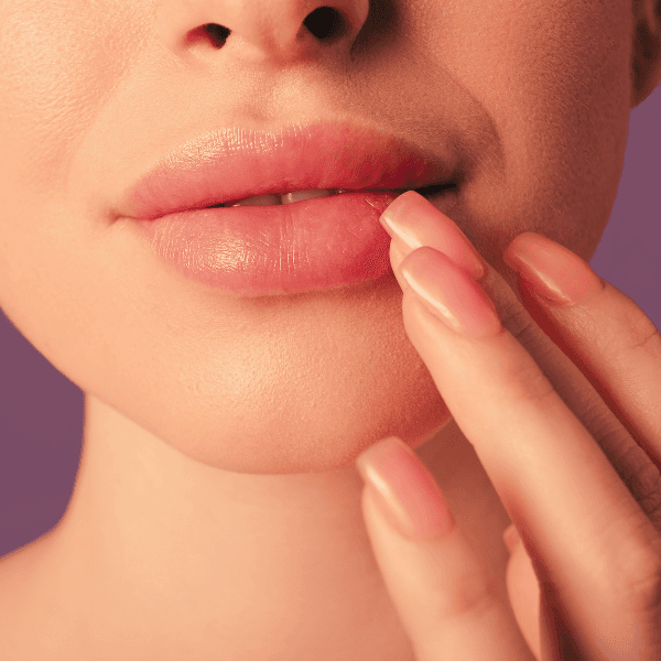 a close up of a woman applying treatment to her lips after lip fillers