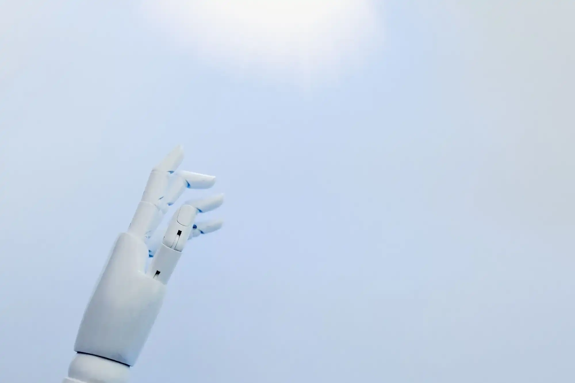 White robotic hand reaching upwards against a blue background