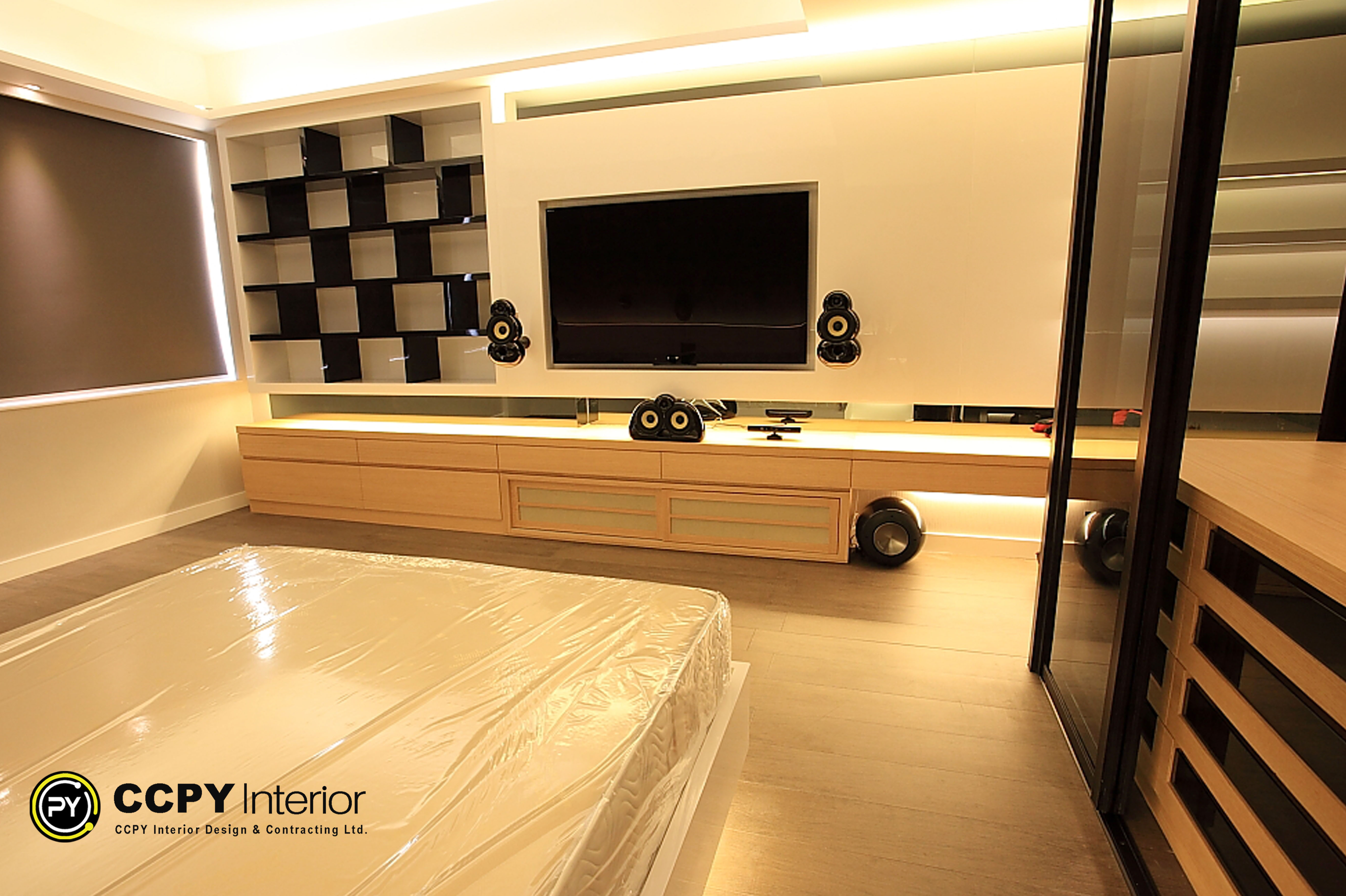 Bedroom media center in Standalone House, Perkins Road with large Sony TV, B&W 800 Diamond speakers, and custom wooden console with checkerboard open shelving.