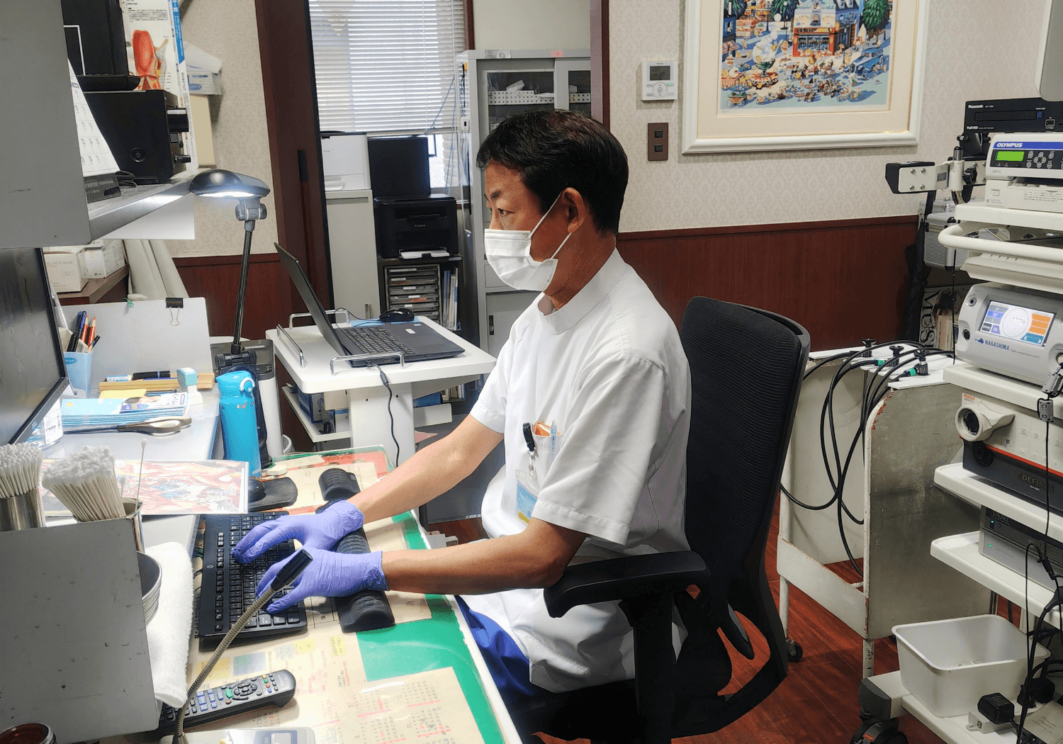 診察室で電子カルテに情報を打ち込む渡邊雄介先生