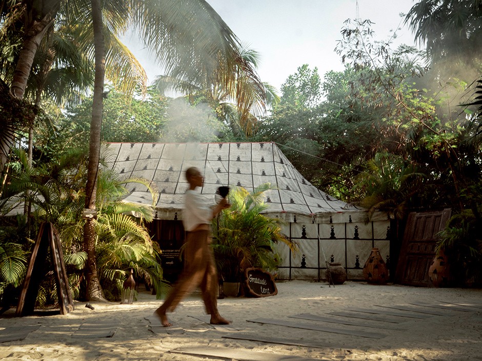 Group of people discussing their spiritual yoga journey on the beach at Nomade Holbox in Tulum Mexico, with a serene and peaceful atmosphere