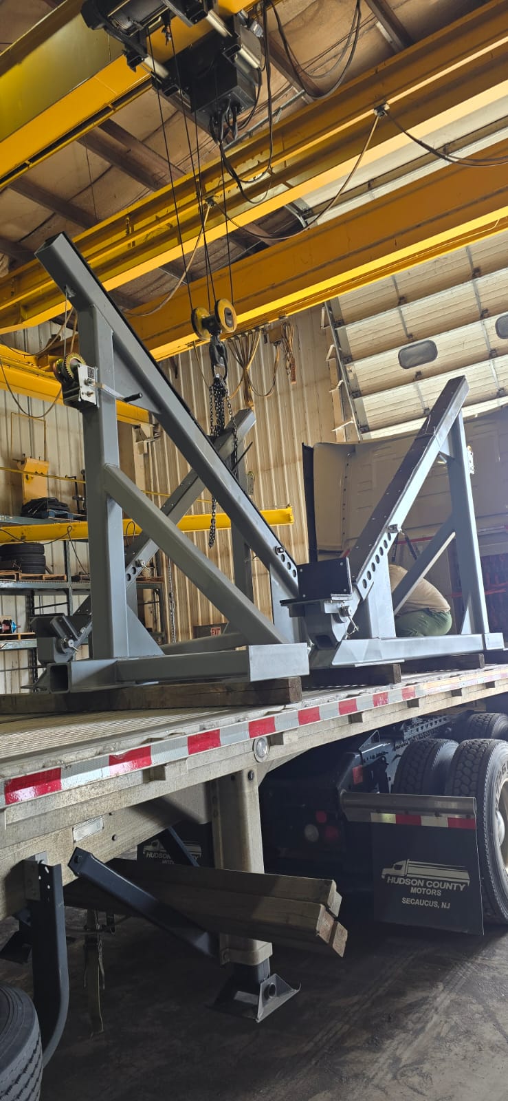 Close-up of a dark green leaf showing its textured surface and central vein against a muted background.