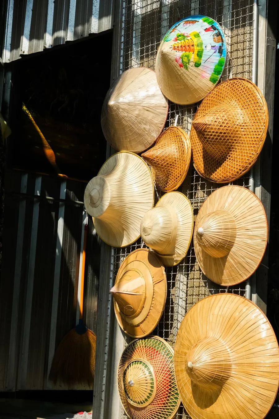 Colourful Vietnamese-style conical hats and woven bamboo hats for sale at a Bangkok market stall