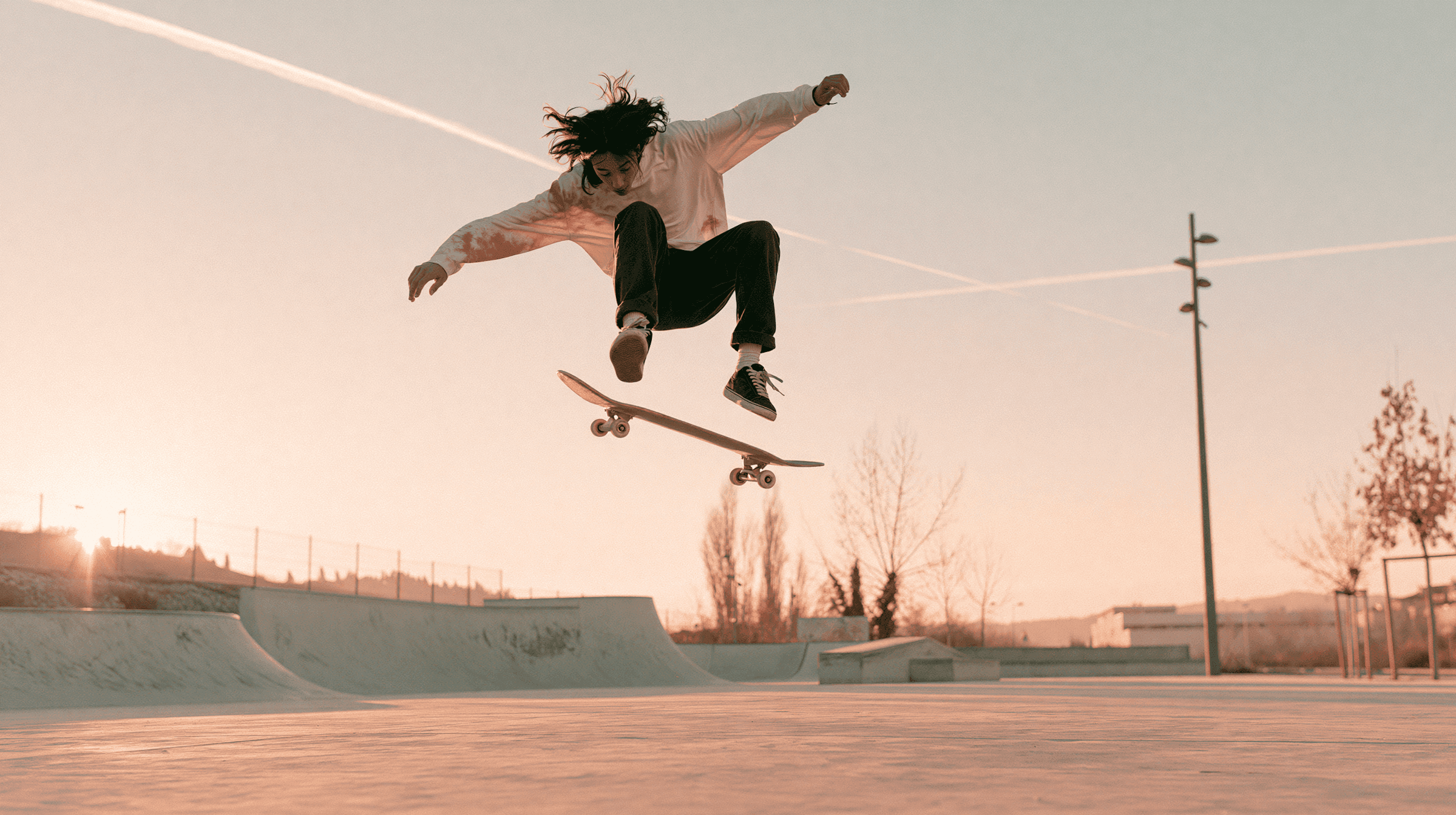 A skateboarder mid-air at golden hour