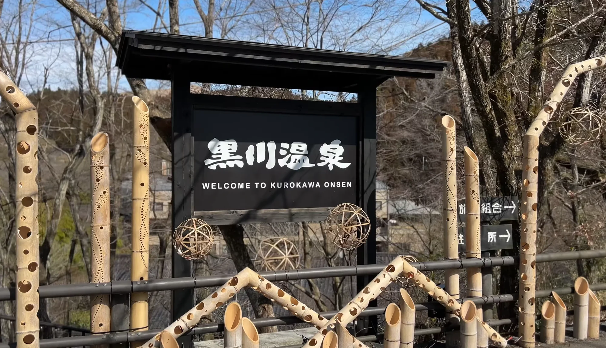 The Kurokawa Onsen entrance gate in dark timber and bamboo carrying the village name
