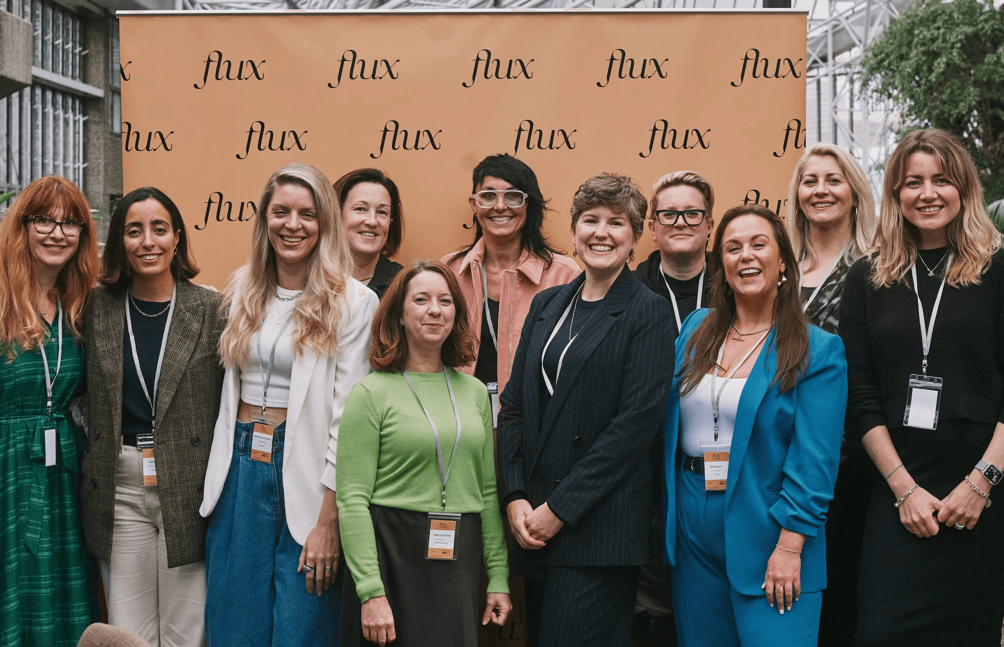 Eleven women, founding members of Flux, a community for senior design and UX leaders, standing together facing the camera.