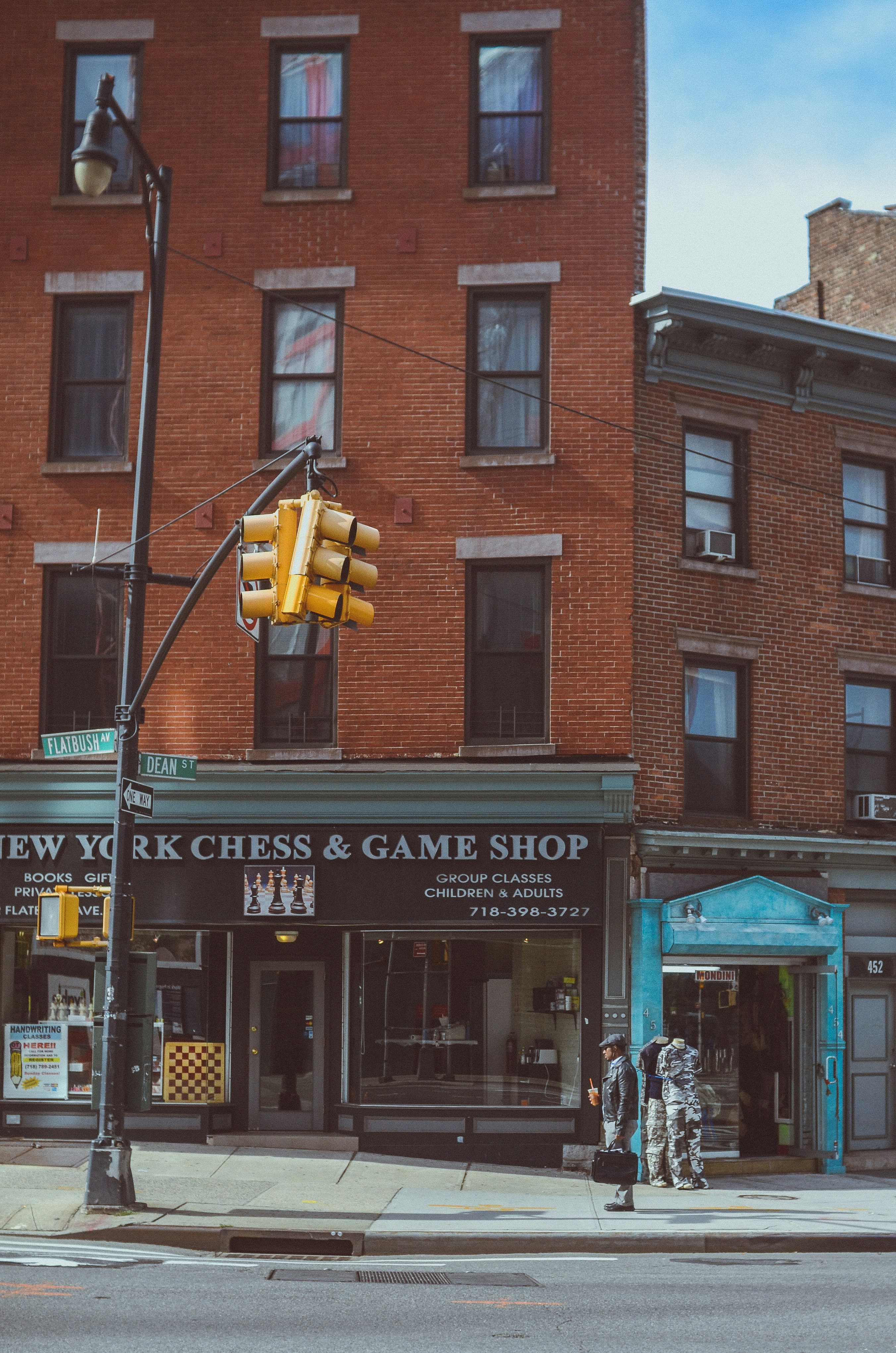 a street corner with a traffic light and a game shop