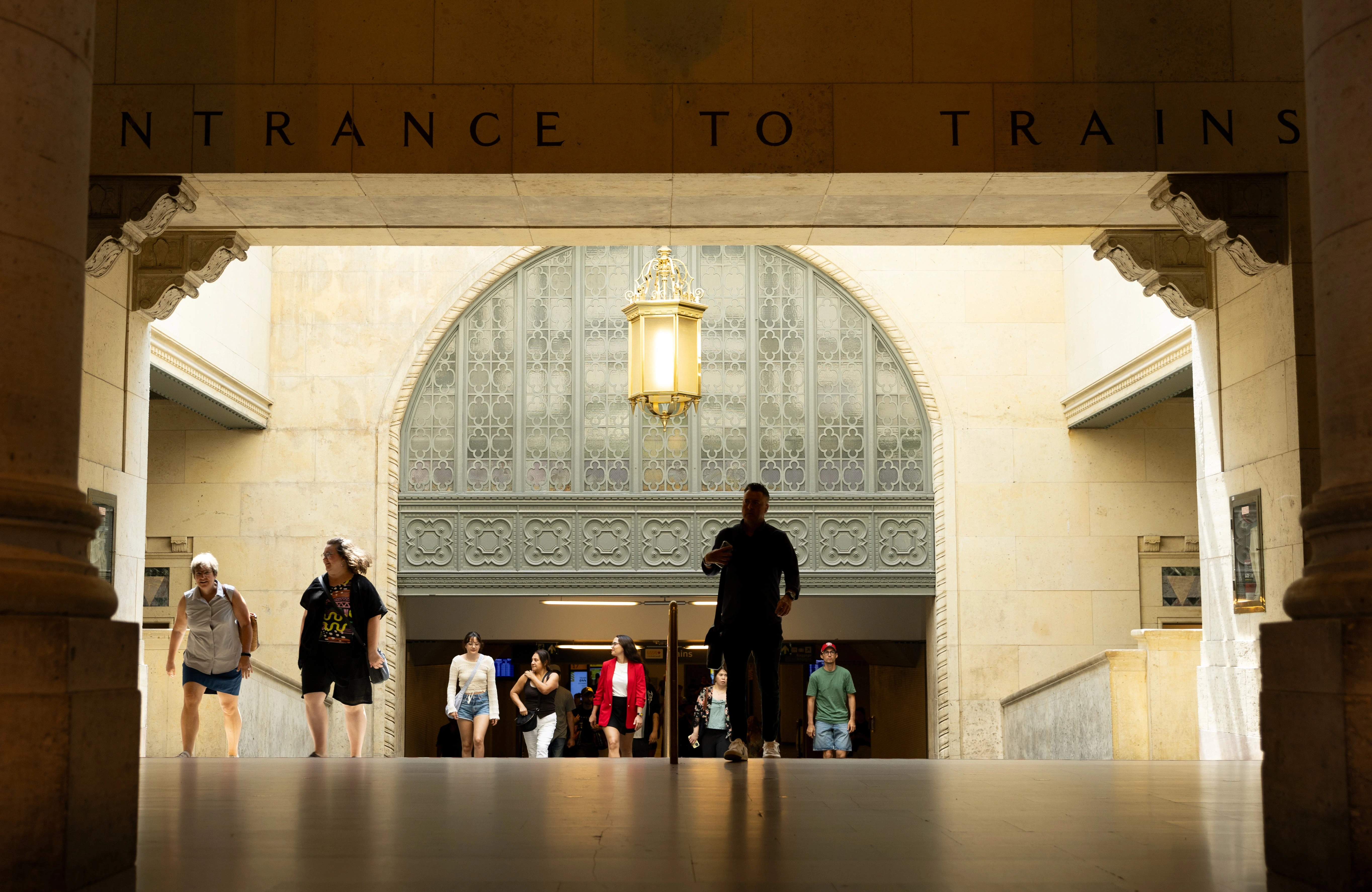Entrada para área de trens na Union Station em Toronto, com pessoas subindo as escadas.