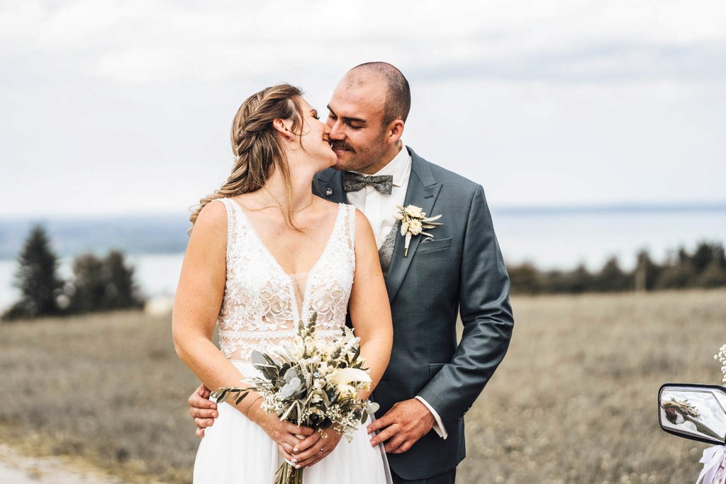 Brautpaar blickt sich lächelnd an bei Hochzeitsshooting im Freien mit Bergblick