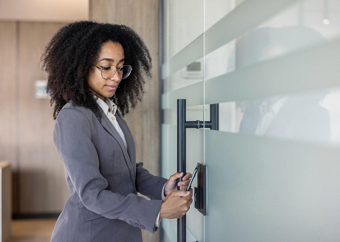 Una donna utilizza un rilevatore presenze dipendenti per effettuare la timbratura mentre accede all'ufficio.