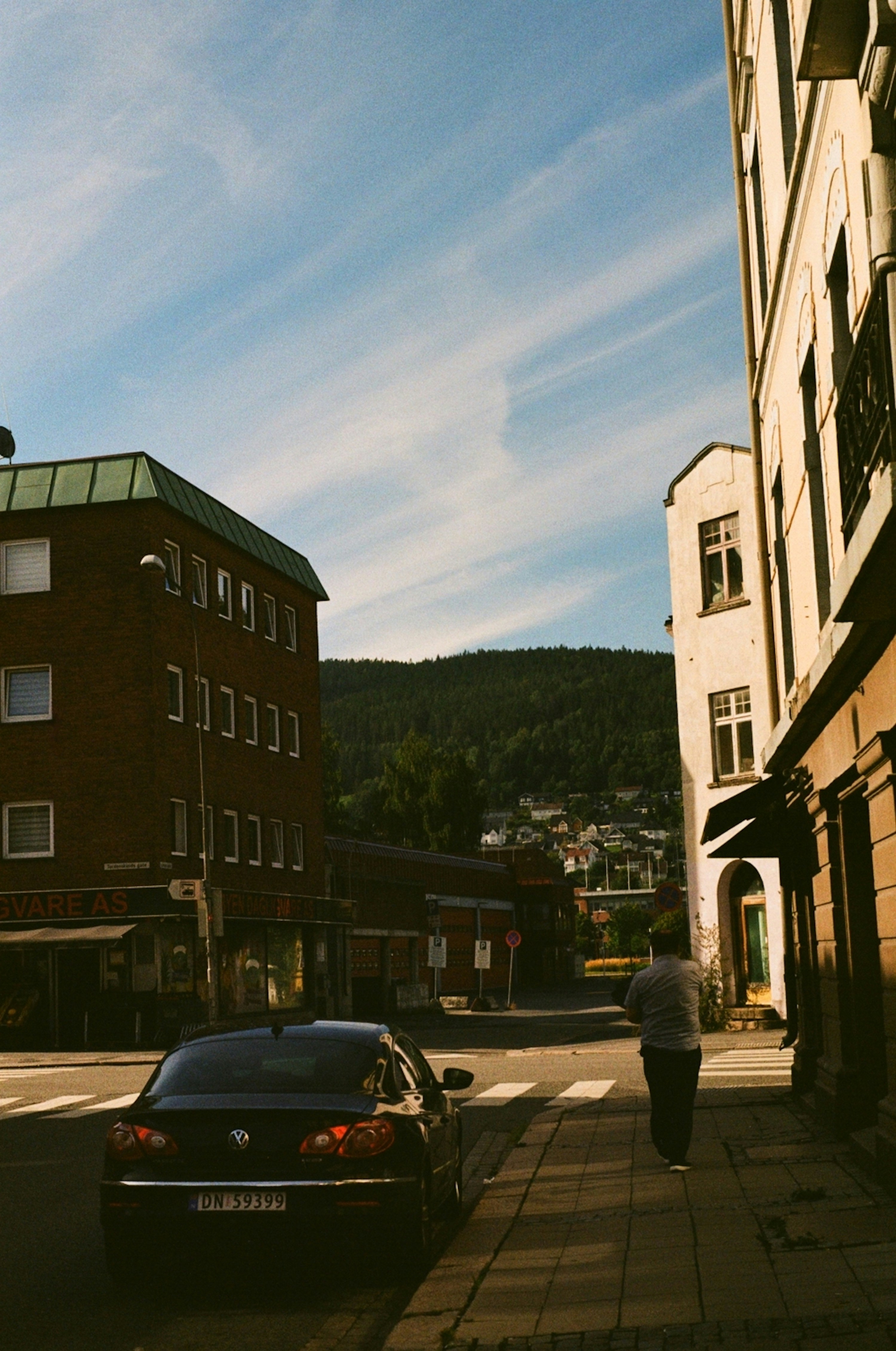 a car parked on the side of a road next to a tall building