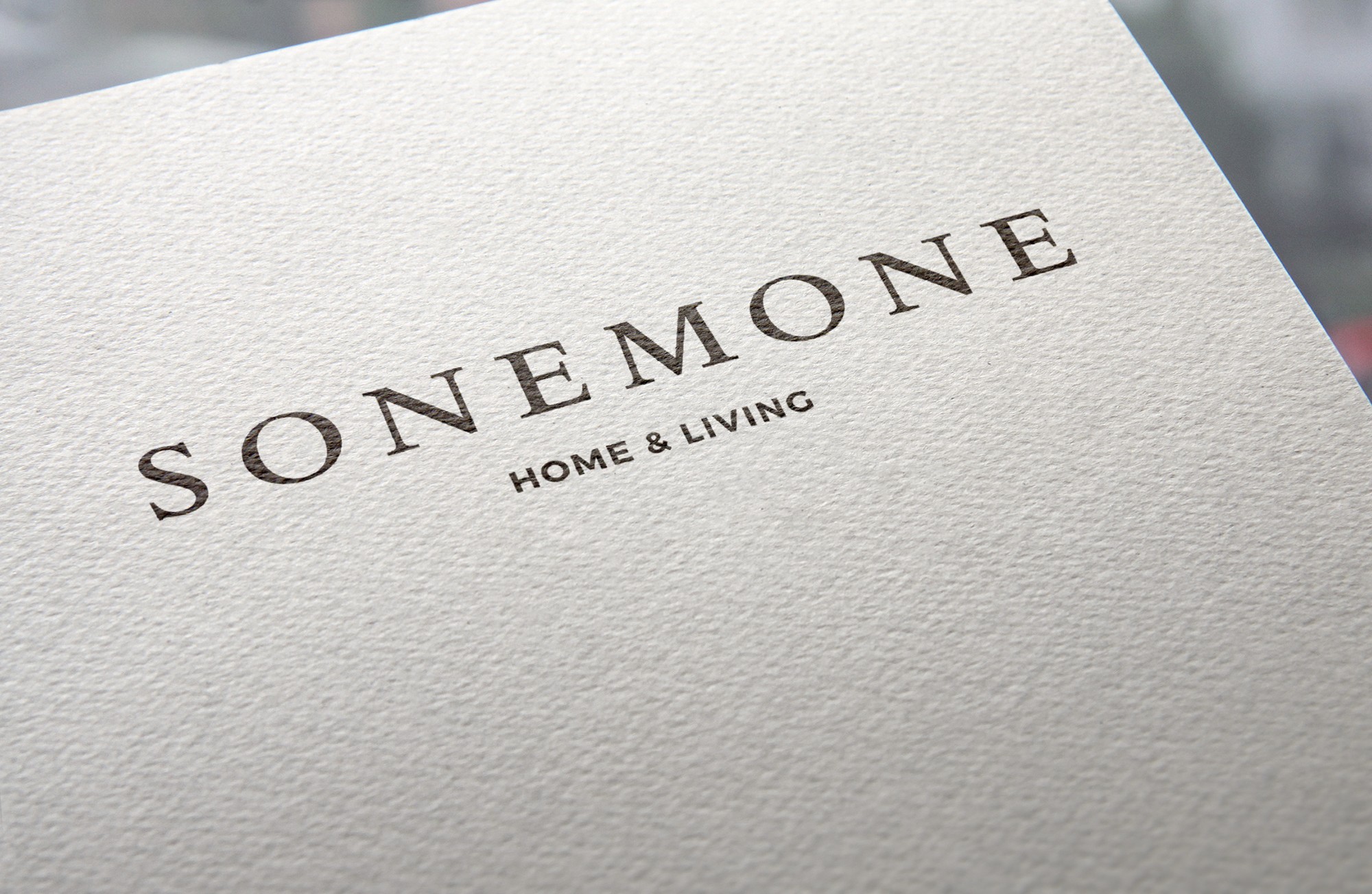 這張圖像展示了SONEMONE品牌識別設計。以簡潔優雅的字體呈現，「SONEMONE」下方有「HOME & LIVING」的字。