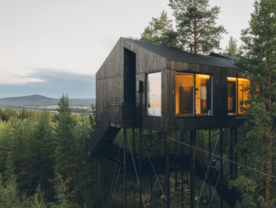 Eine moderne Hütte im Wald im pinken Licht