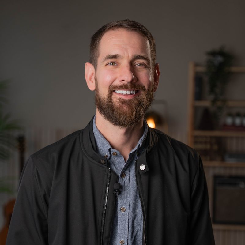 Autumn leaves floating on dark water with rain ripples.