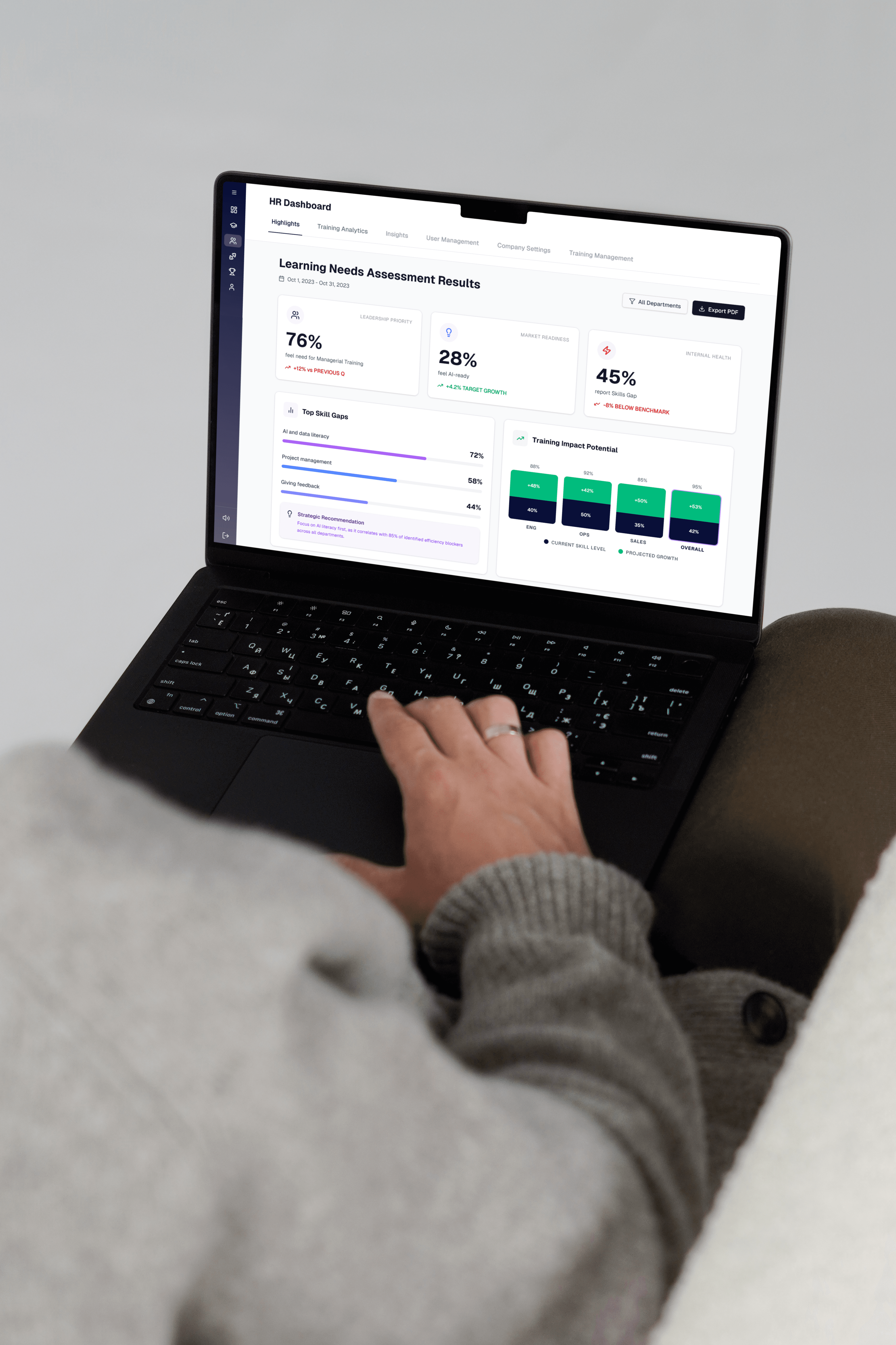 Person using a laptop showing an HR dashboard with learning needs assessment results and skill gap analytics
