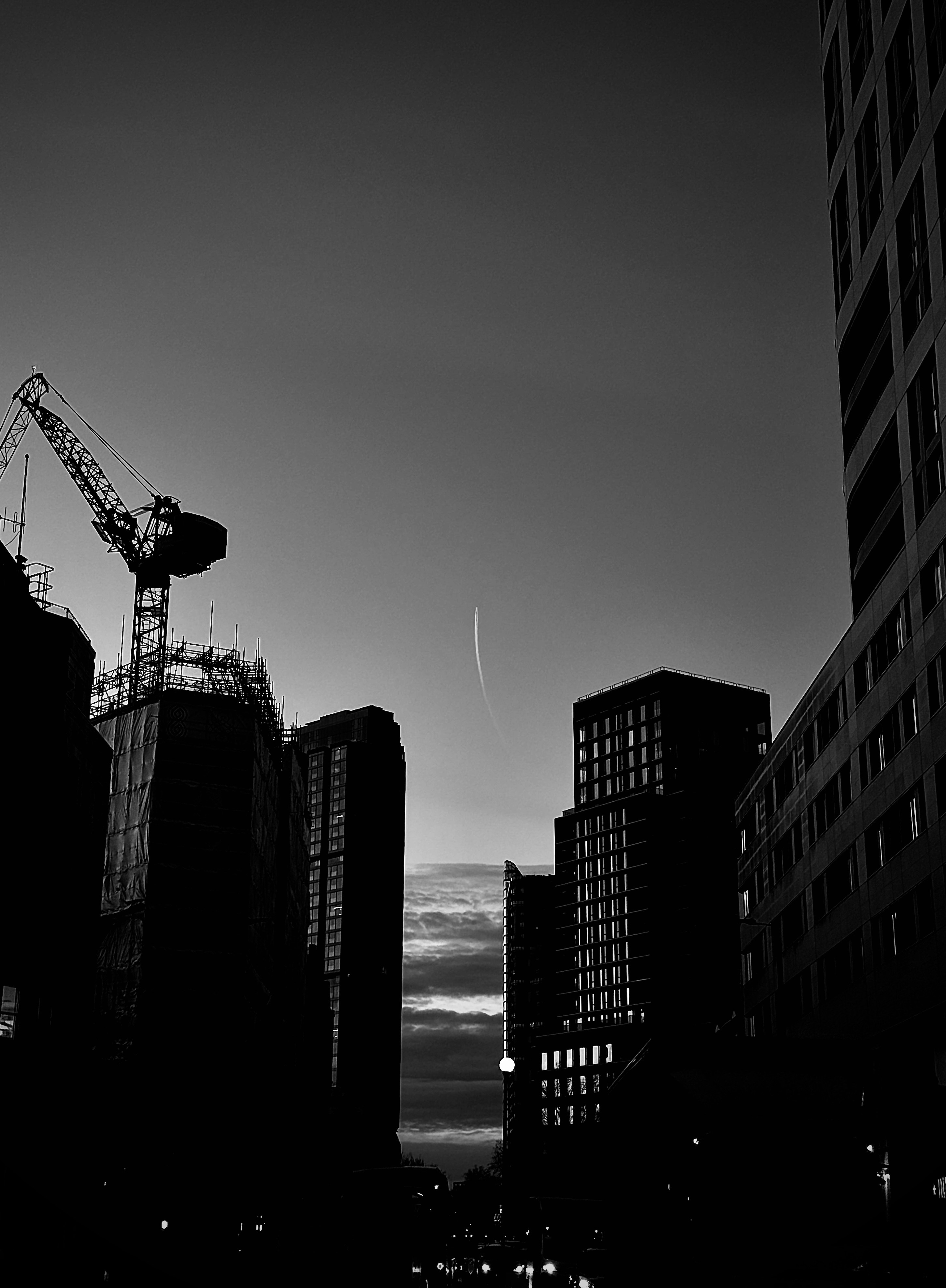 Silhouette of buildings and crane at sunset