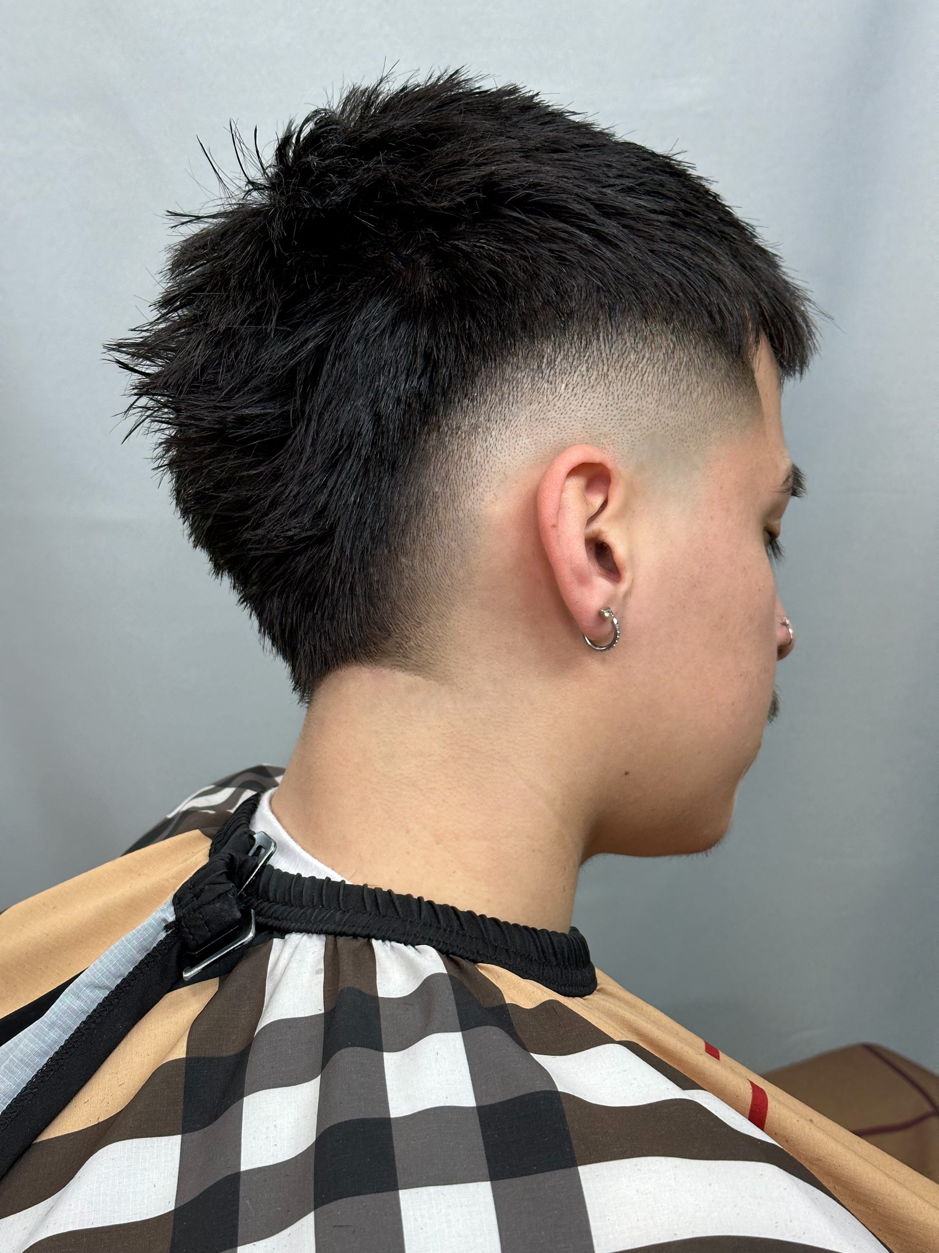 Man with textured crop haircut, high skin fade, and tapered neckline.