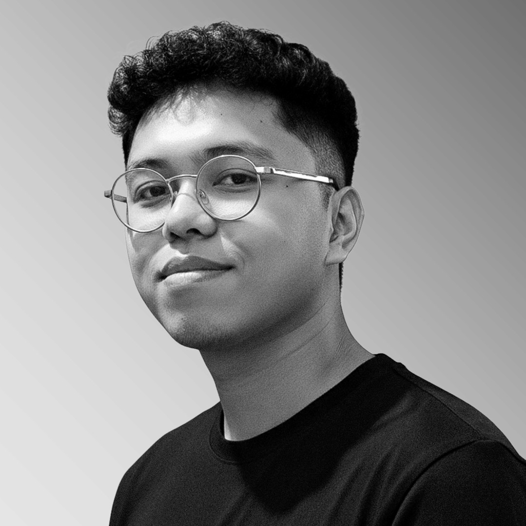 A thoughtful young person with dark hair gazes to the side, captured in soft black and white lighting.