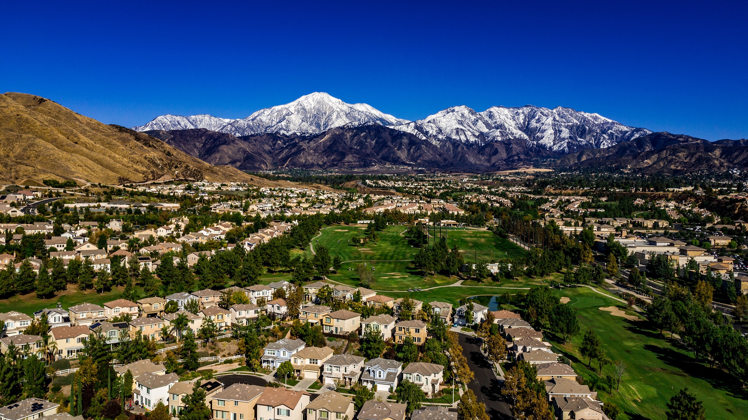 A view of a mountain range from the top of a hill