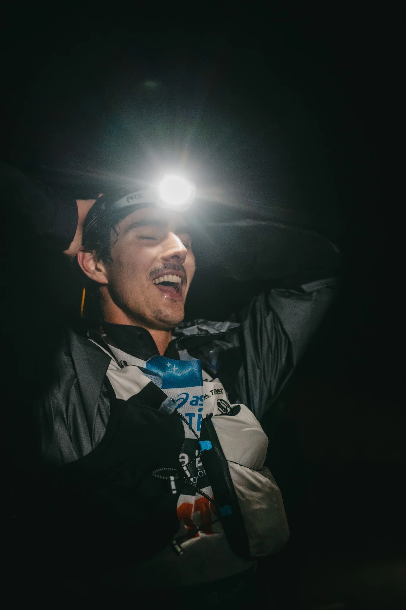 Coureur à la lampe frontale franchissant la ligne d’arrivée de la SaintéLyon de nuit, entre performance et émotion