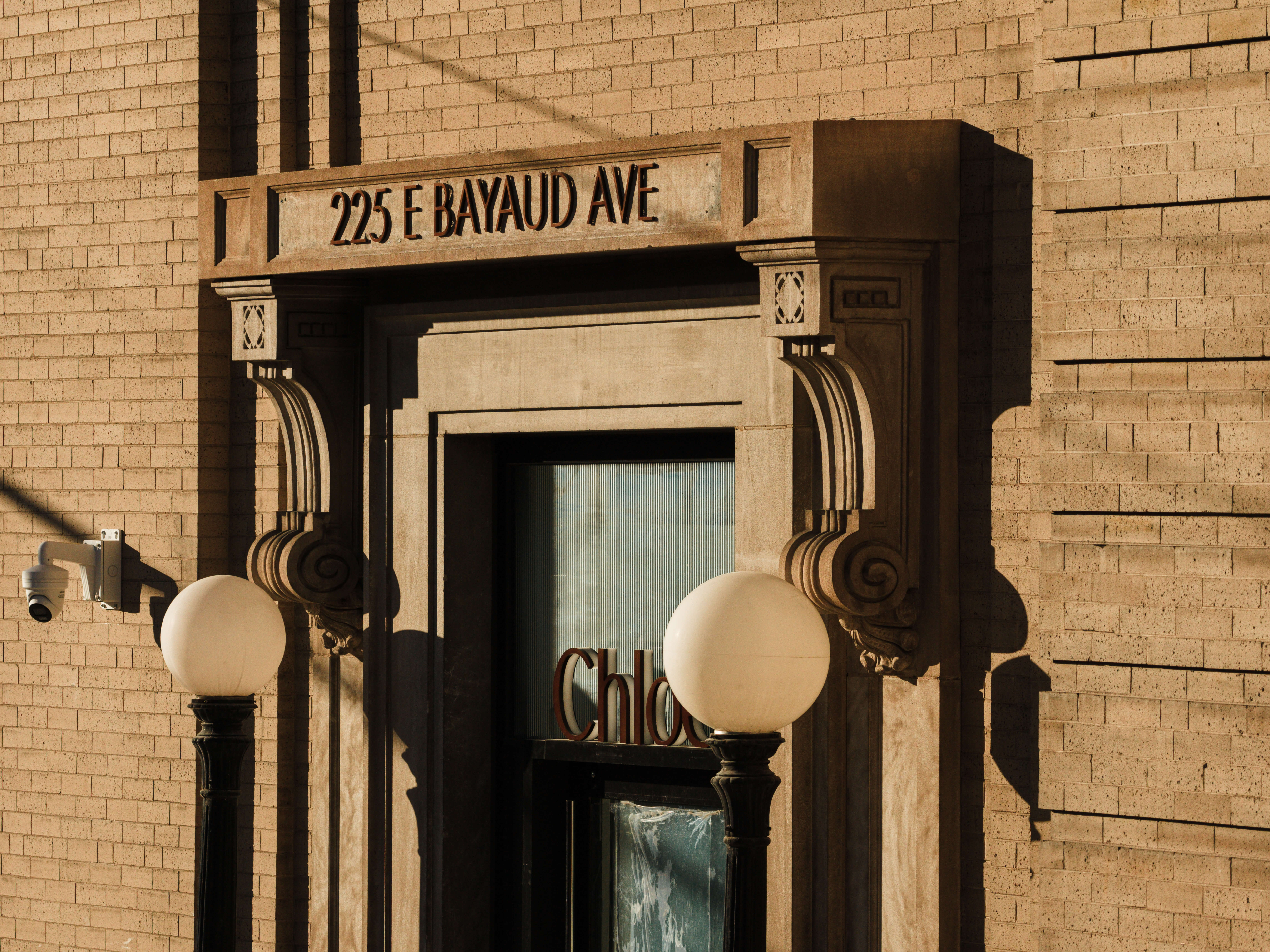 pair of gold-colored earrings on table and black ankle-strap pumps on area rug