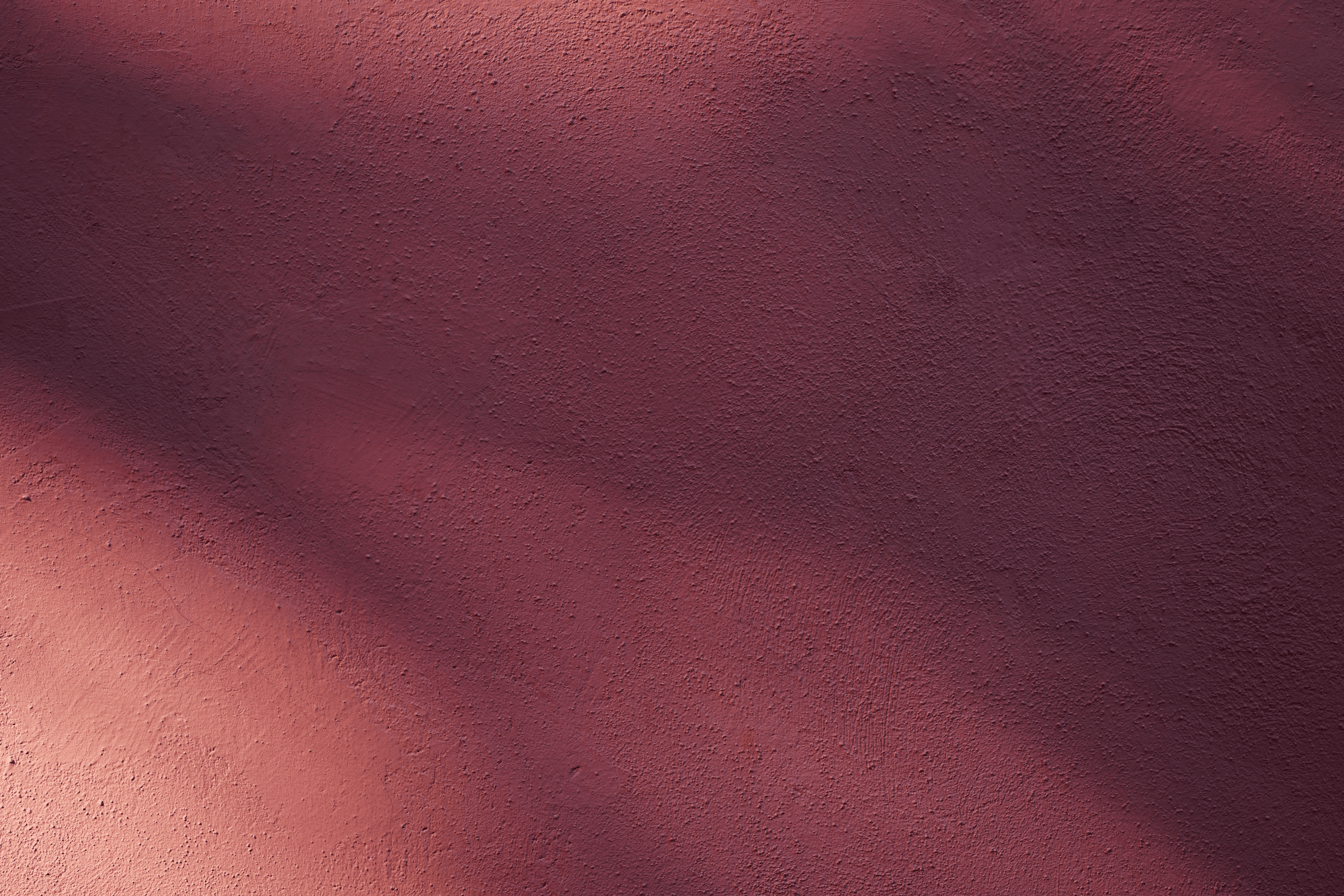 Hands typing on a laptop keyboard on a wooden desk, wearing a brown ribbed sweater