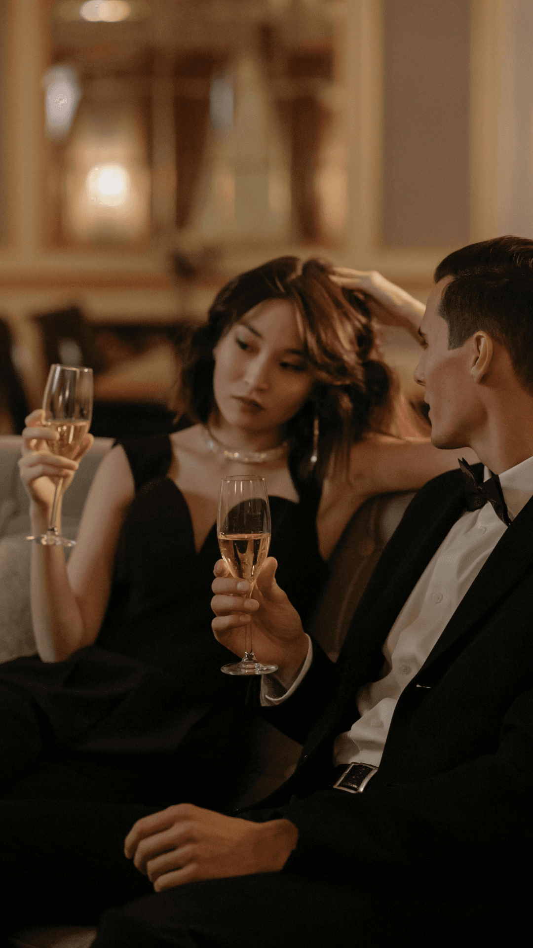 Couple élégamment habillé discutant dans un salon avec coupes de champagne