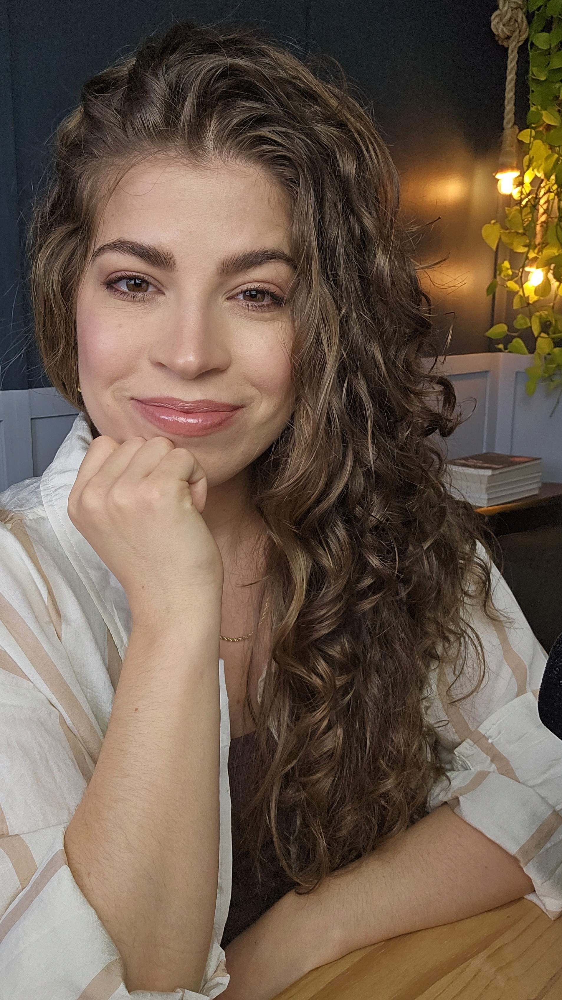 A group of four people engaged in a discussion while seated in a cozy, plant-filled setting.