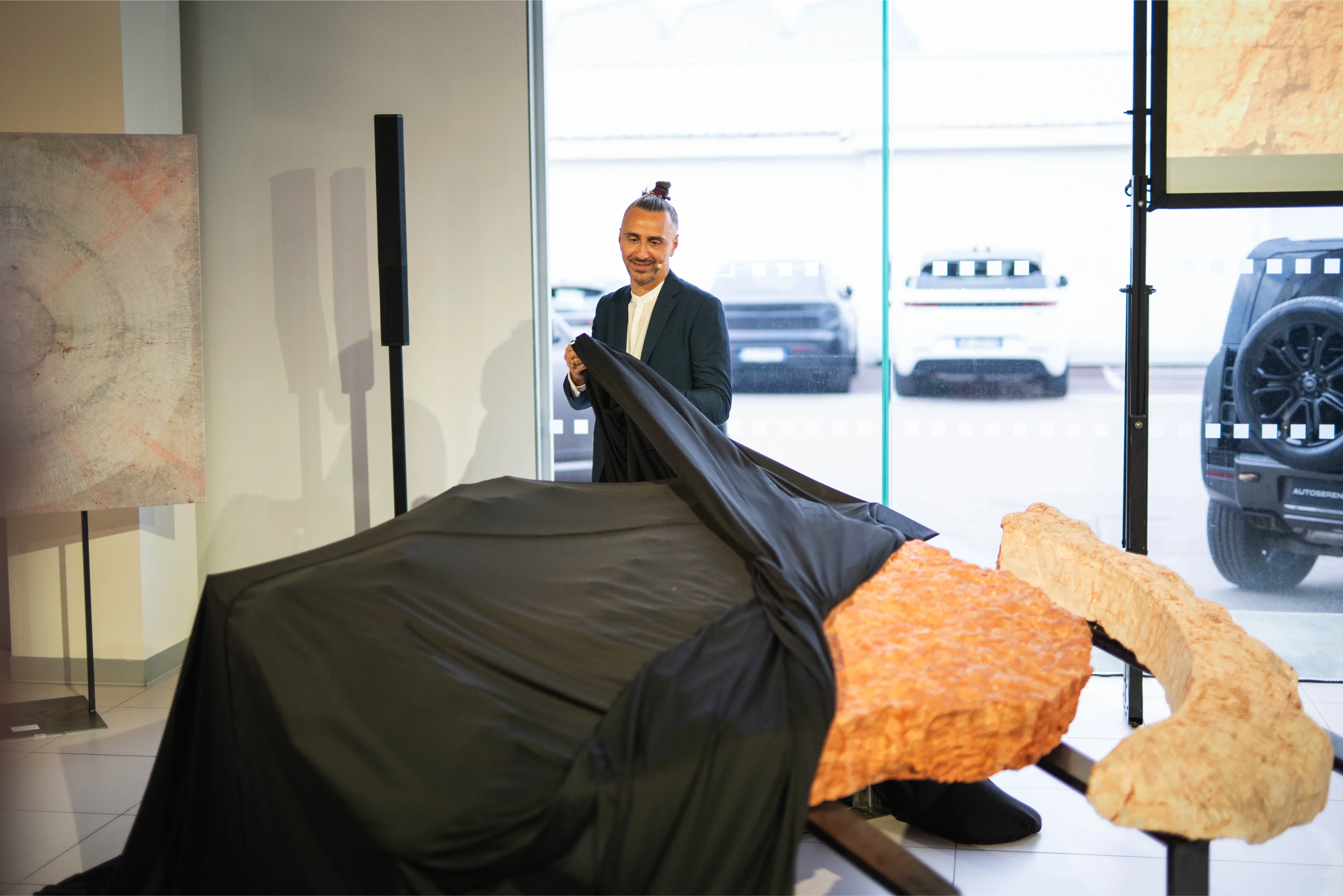 Installazione luminosa iStone Arte con scultura radiale contemporanea su parete durante evento di inaugurazione aziendale, arte come valorizzazione del brand