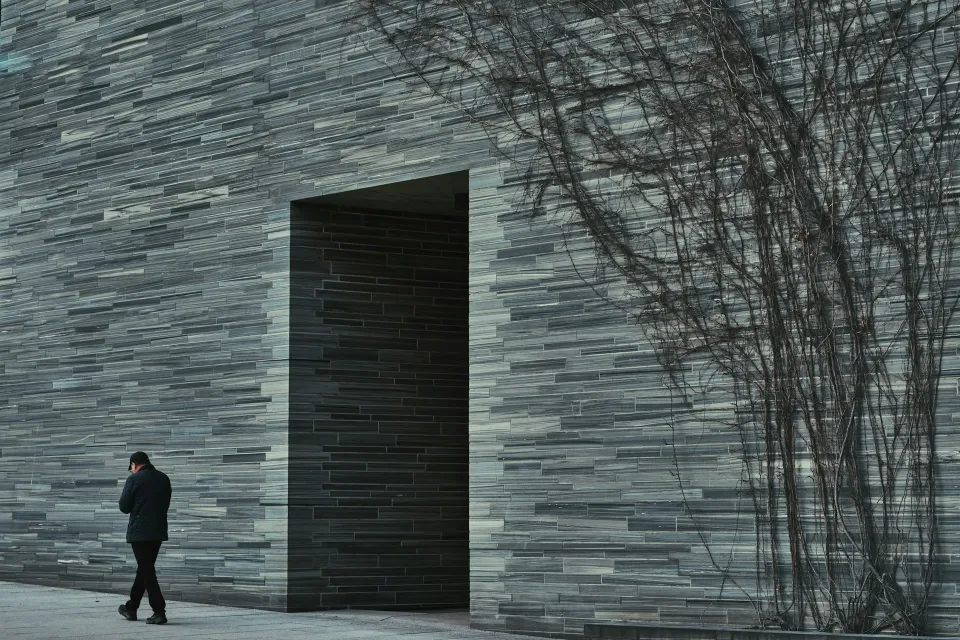Slate-clad entrance with a recessed doorway and climbing vines