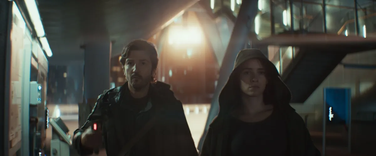 Cassian Andor and Bix Caleen from Andor Season 2 walking away from an explosion