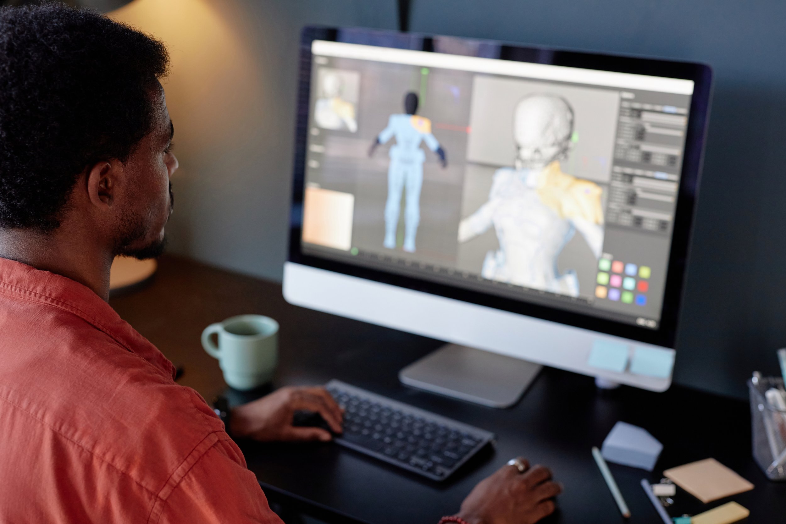 An animator working on a three-dimensional human character on a desktop monitor.