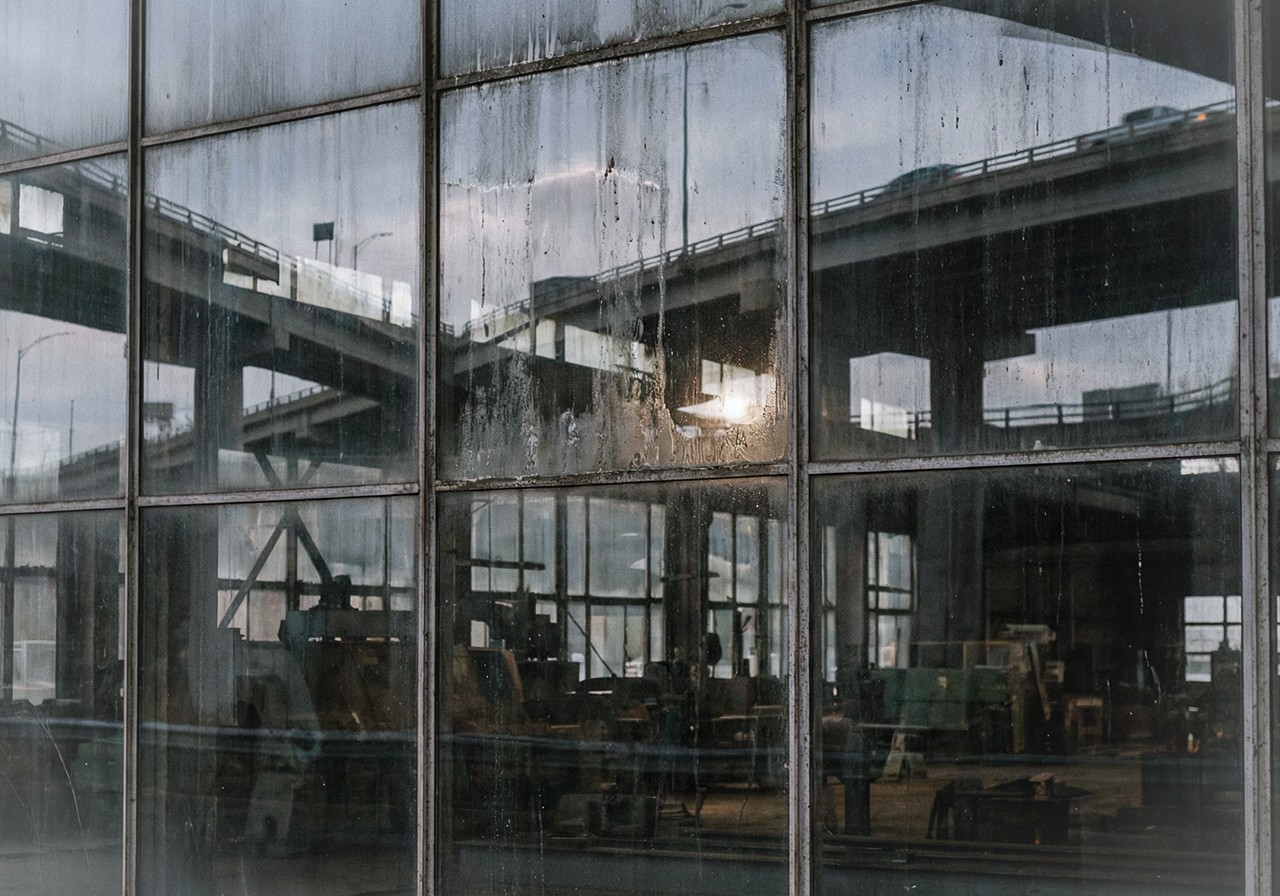 A talent recruiter with a soft smile working on her laptop in the office. The angle is on her face so we can't see what's is on the screen. She is wearing a blazer 