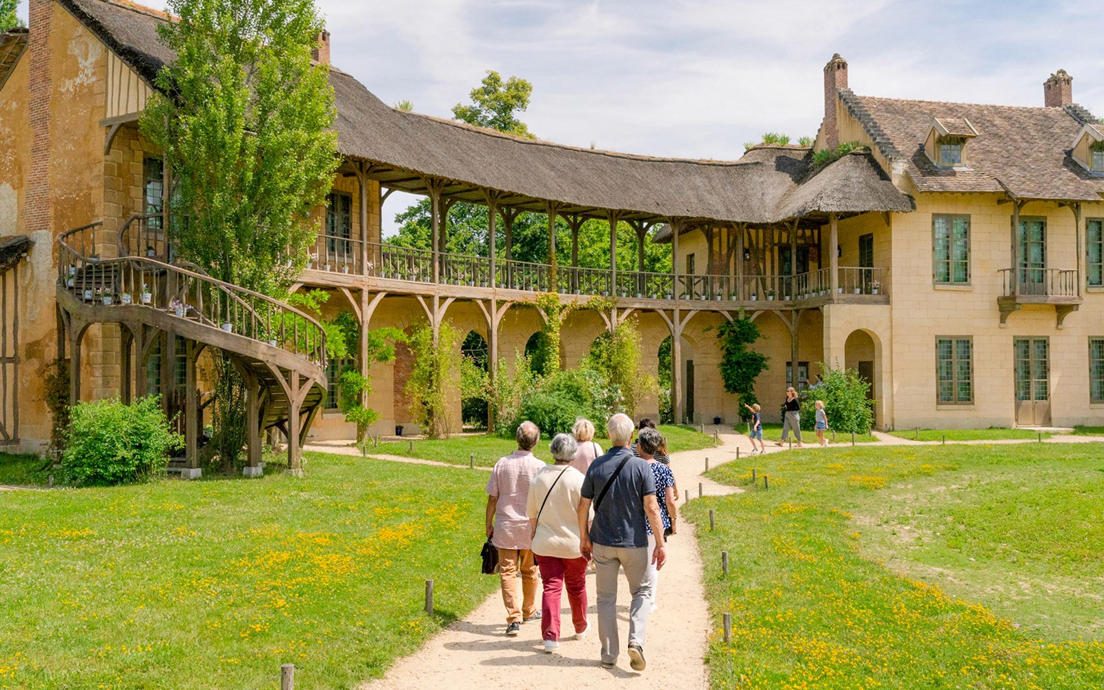 Pengunjung berjalan menuju Domain Marie Antoinette, Istana Versailles.