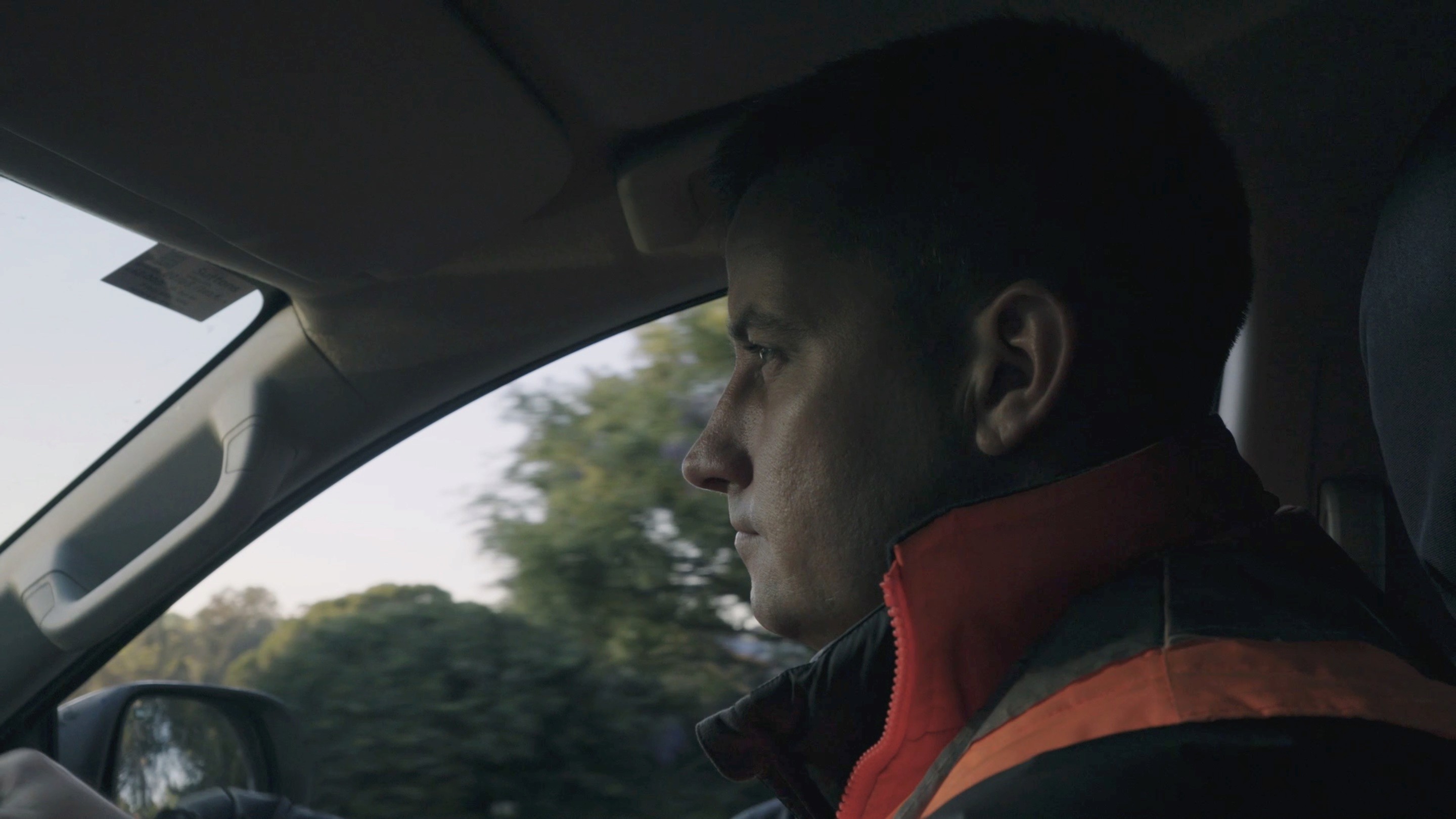 close up of man in high vis gear driving