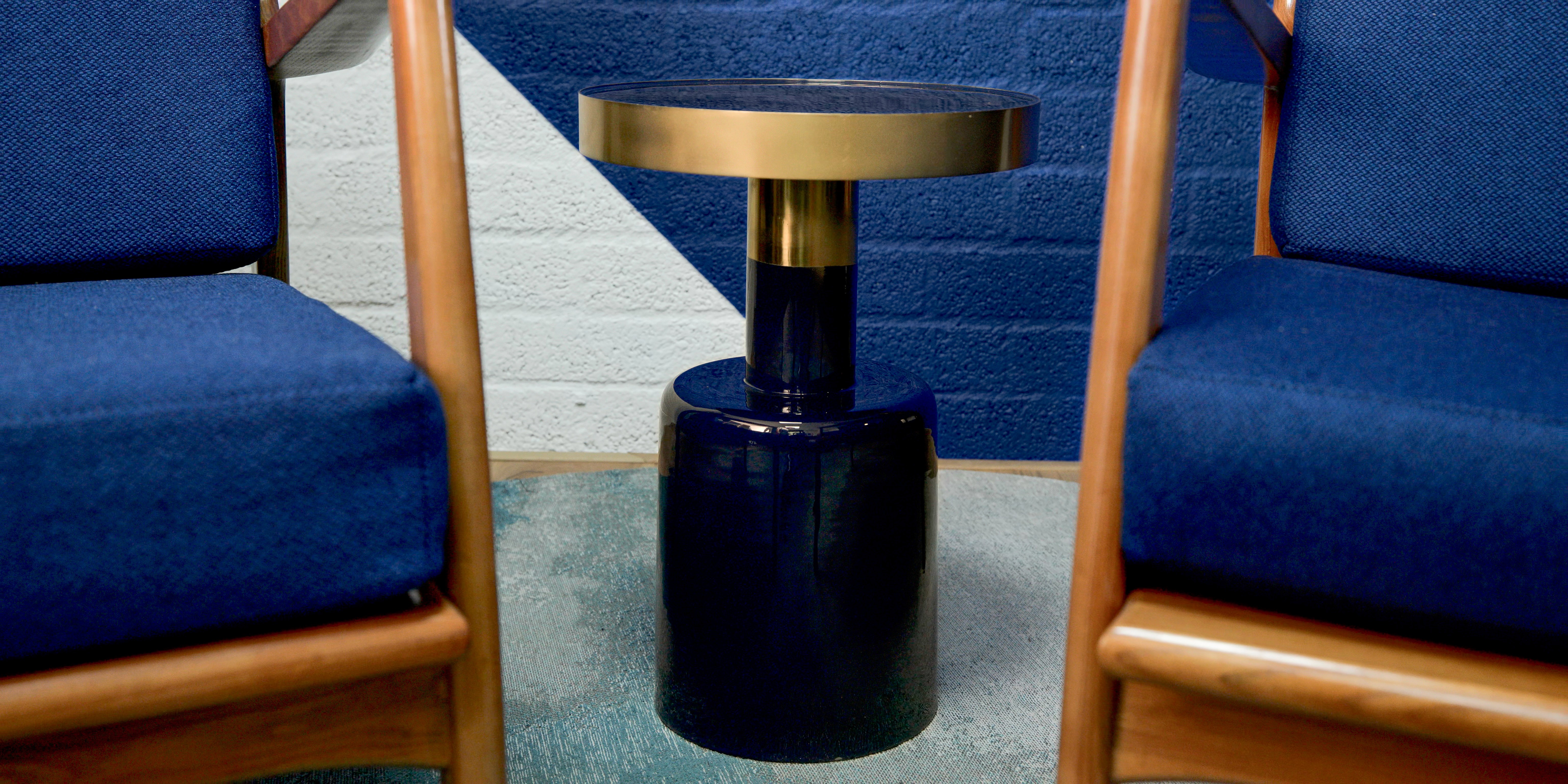Blauwe fauteuils met koperen poten en gouden bijzettafel in lounge Oostendorp Nederland