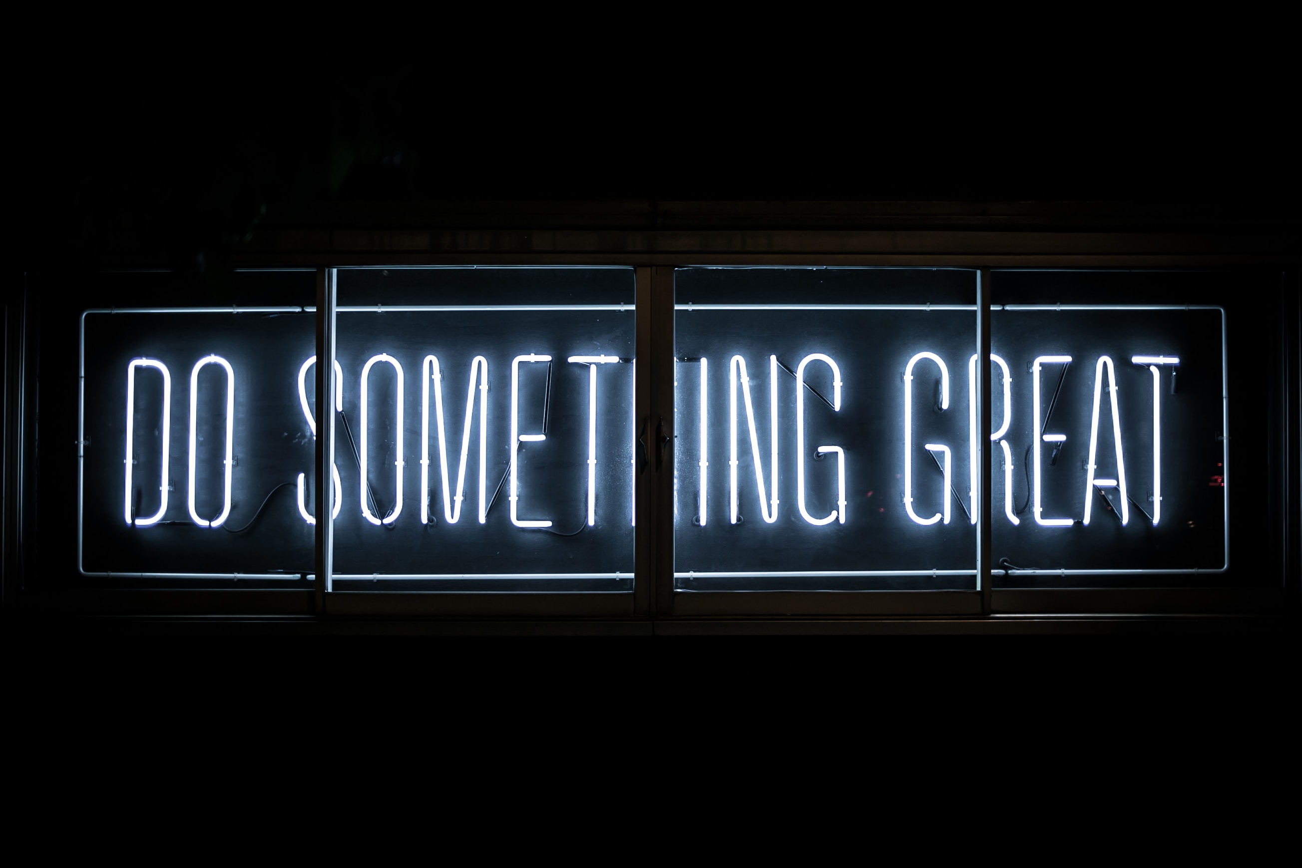 Sign that says "do something great" outside of AI rapper voice generator event