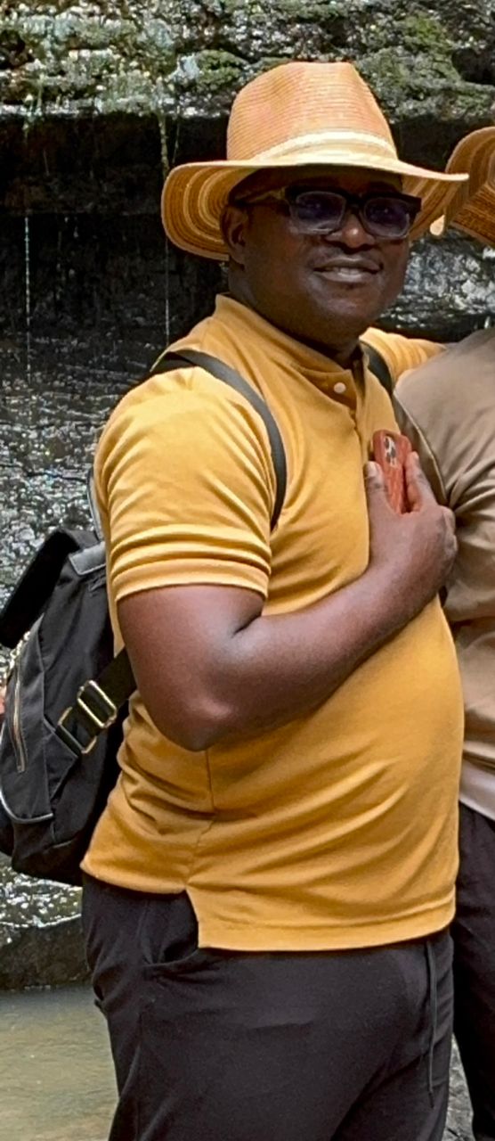 african man in yellow polo shirt and hat