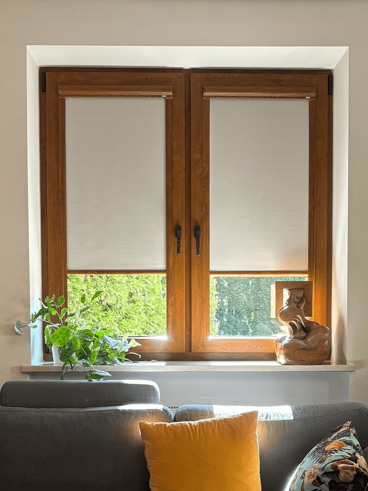 Beżowe rolety materiałowe osadzone na oknach w stylu imitacja drewna. Realizacja wykonana w Pruszkowie.