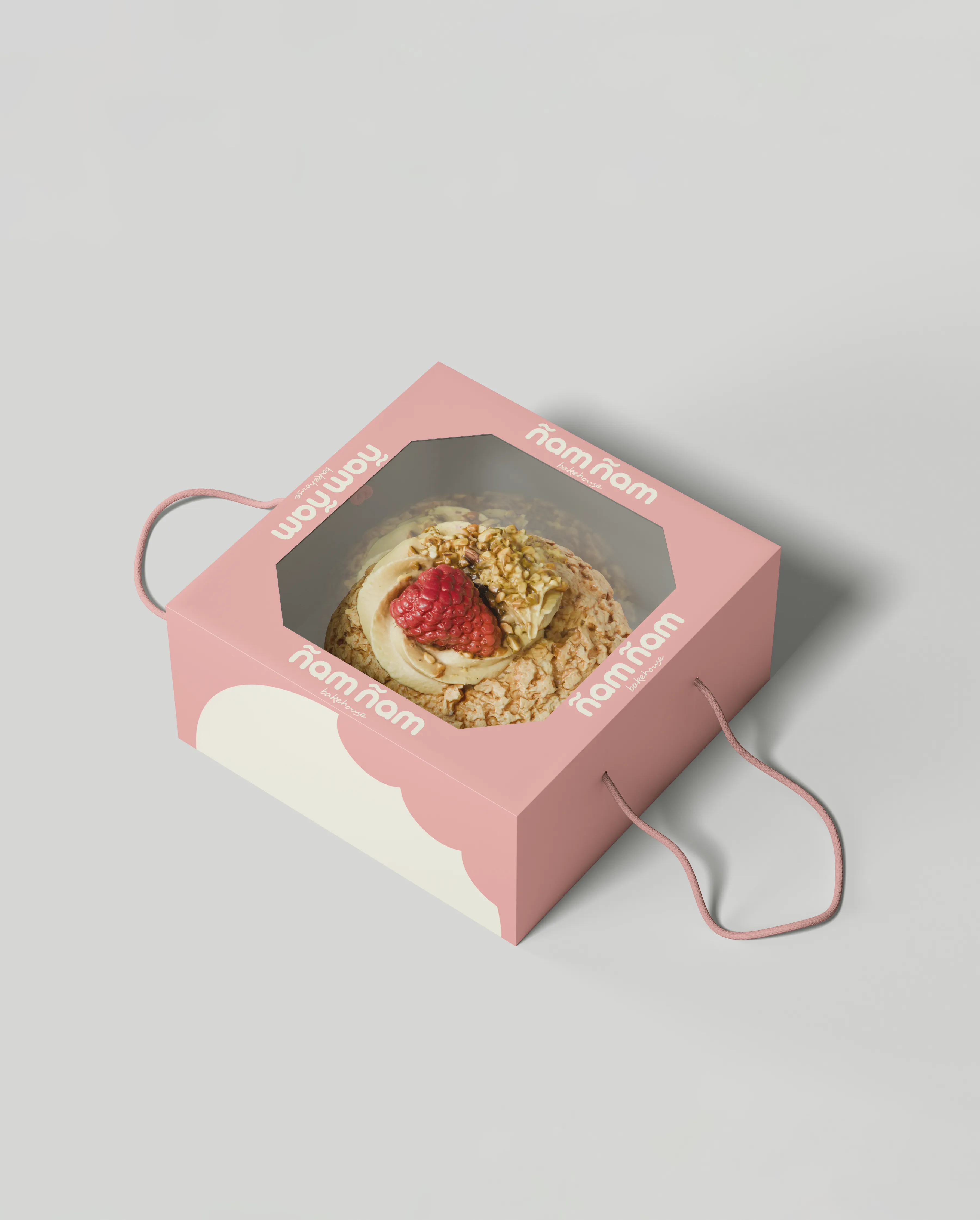 Caja rosa de repostería con logotipo de Ñam Ñam