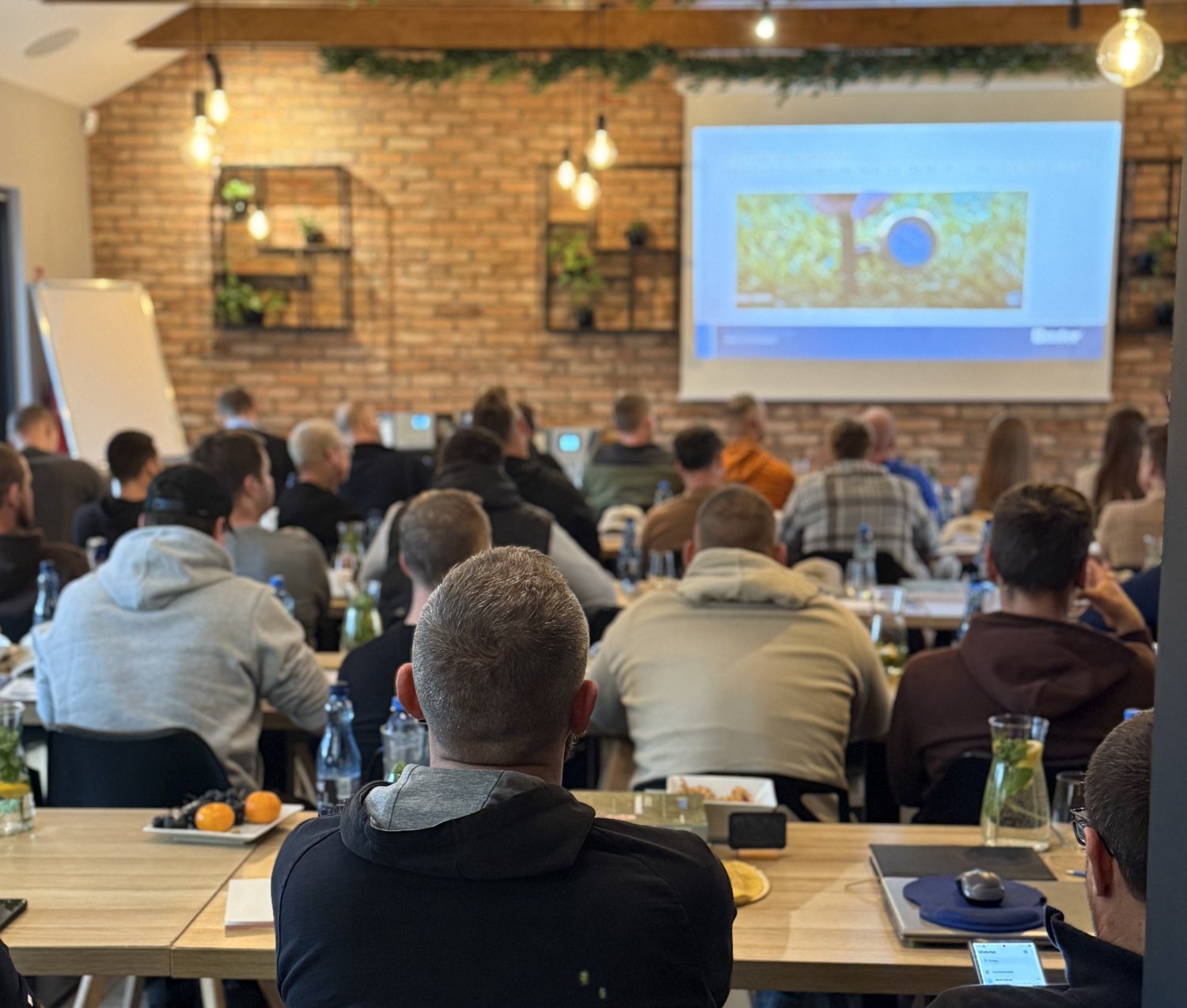 Uczestnicy szkolenia biznesowego korzystający z prezentacji w sali konferencyjnej