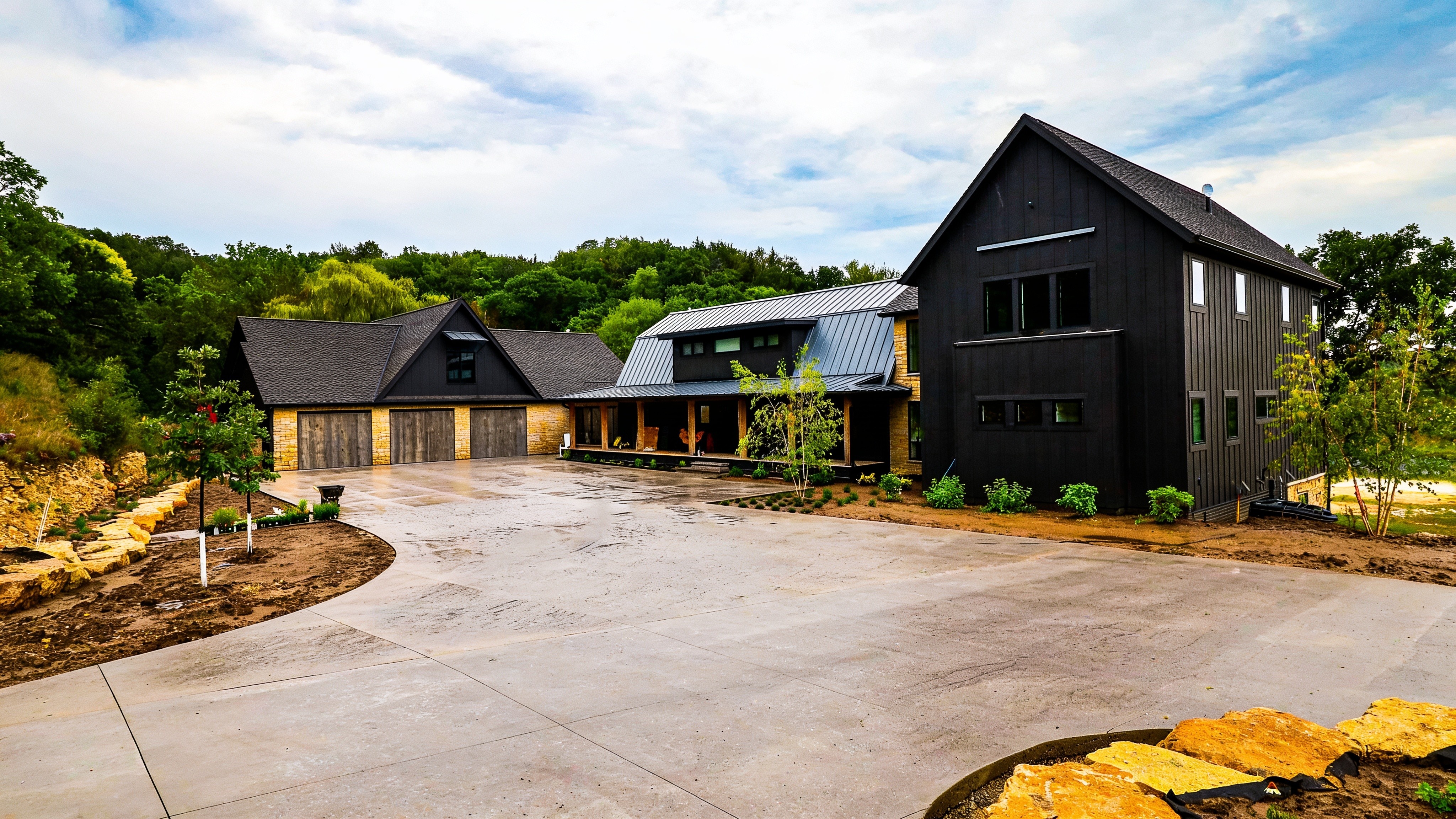 Modern home with three concealed cylinder wood garage doors partly open